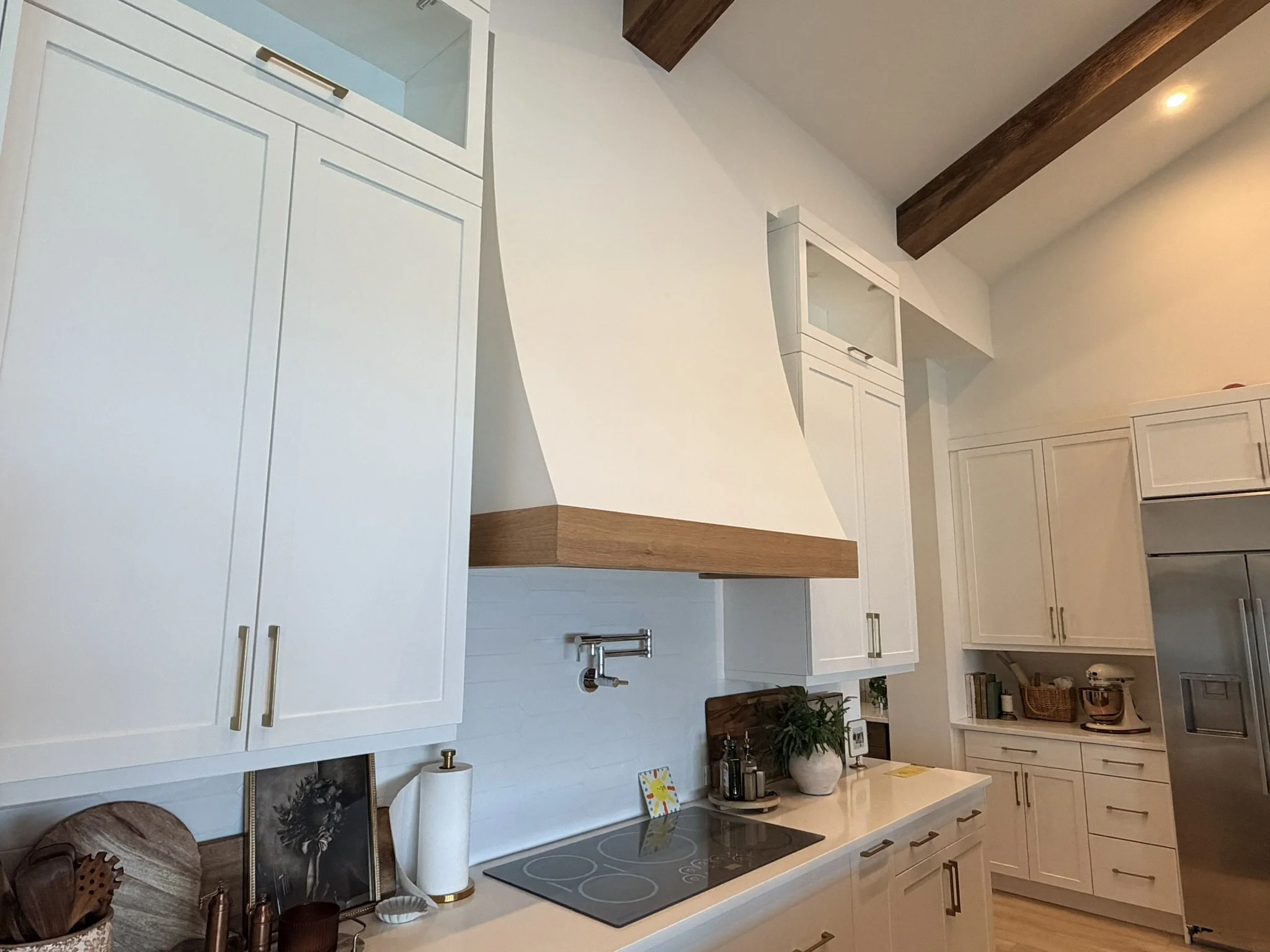 Custom white shaker kitchen cabinets with white oak vent hood trim
