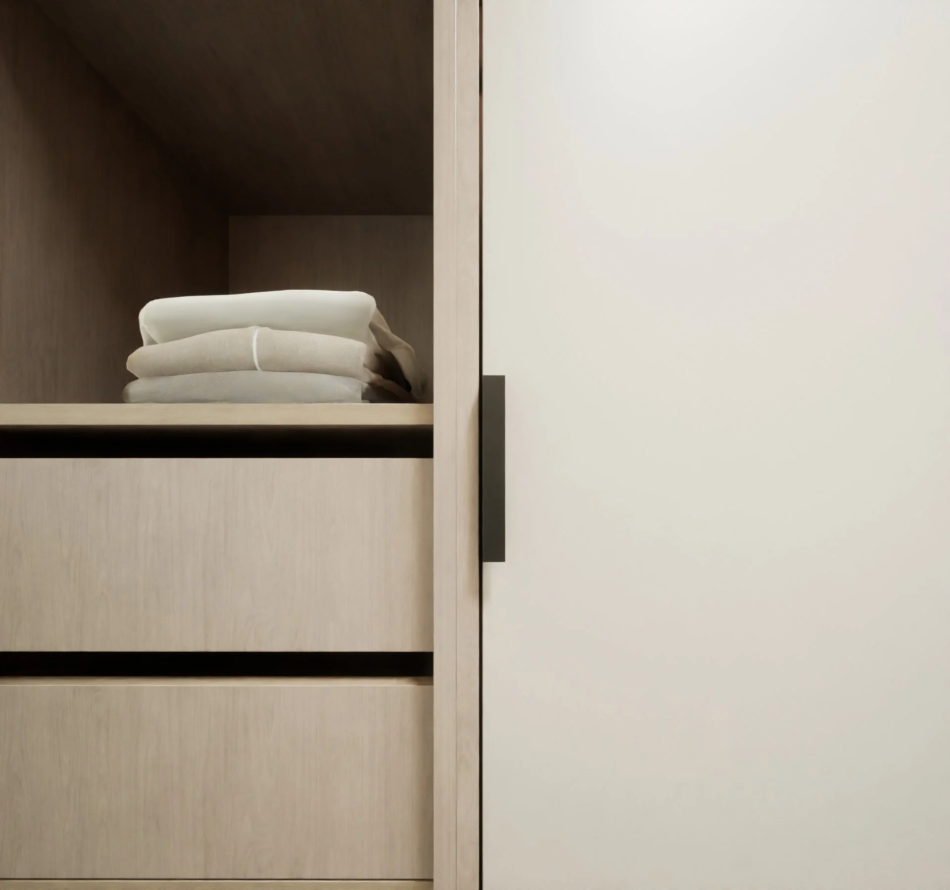 close up image of the dressing room cabinet door with a black metal handle and exposed timber storage with timber drawers below