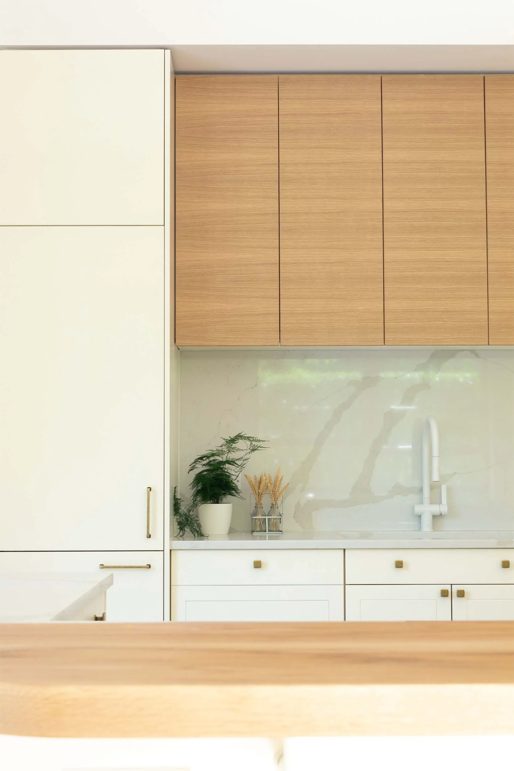 off white fridge door with timber upper cabinets white tap and brass handles