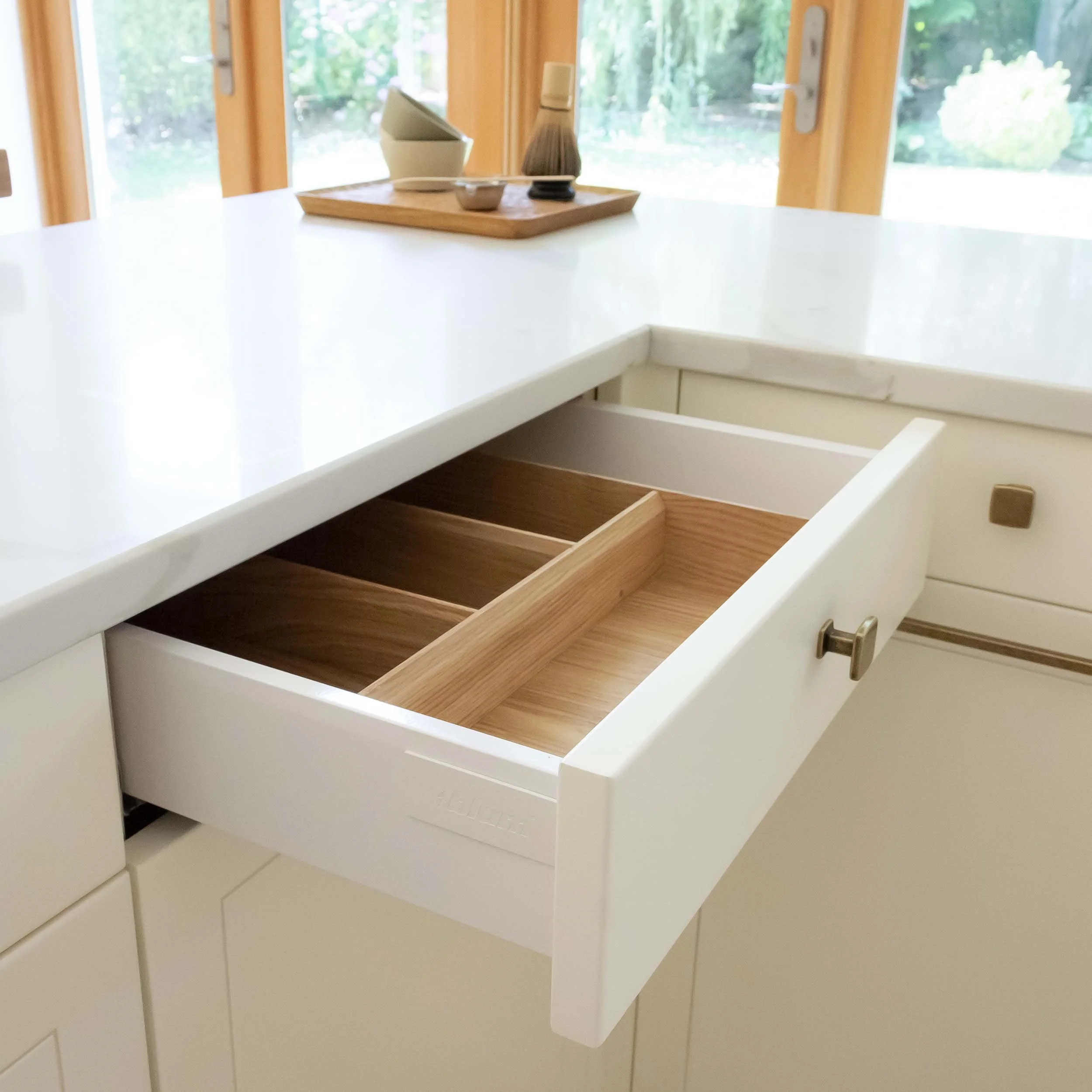 opened drawer showing the timber insert for cutlery and marble worktop
