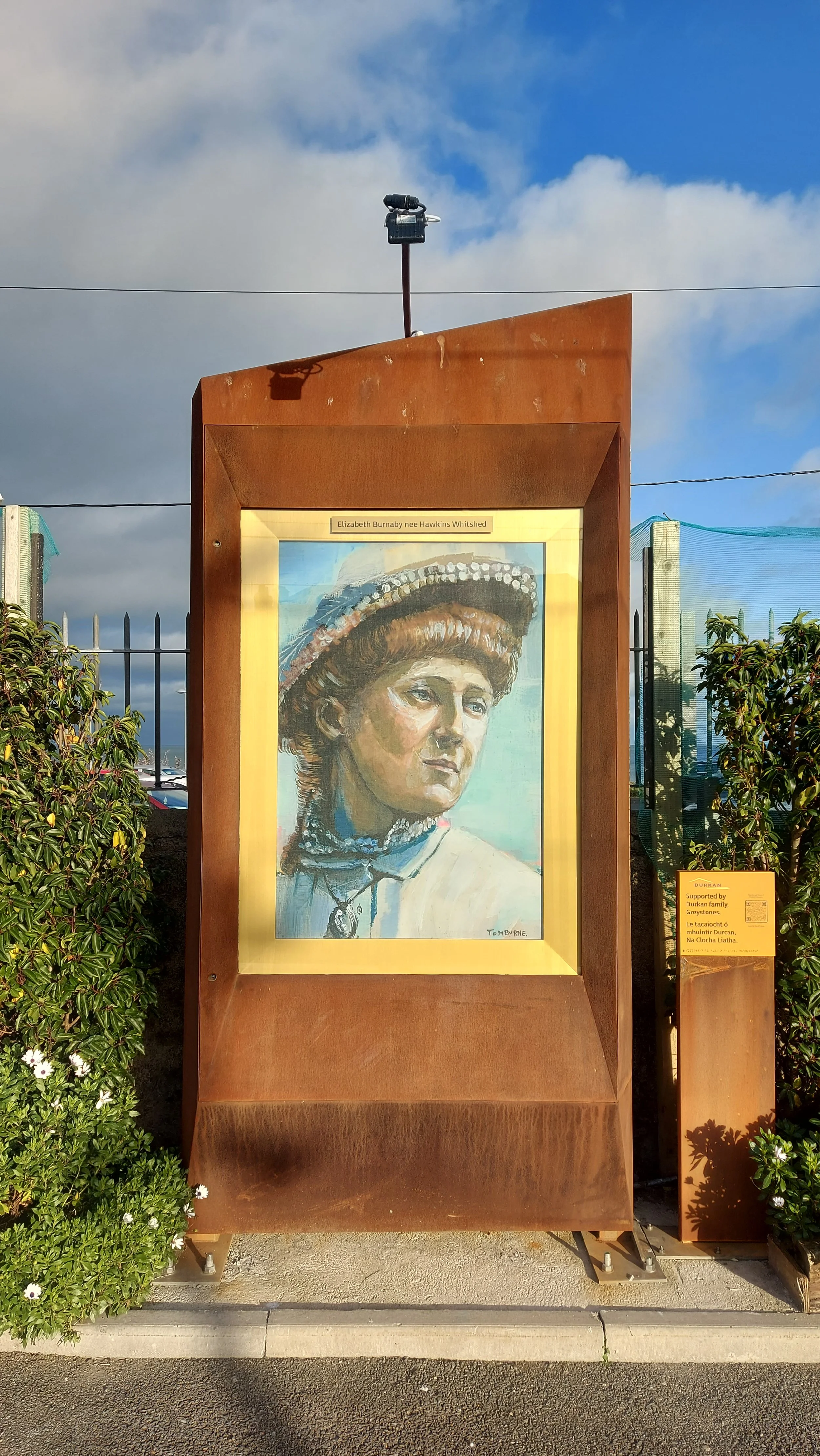 corten steel totem with a brass inlay surrounding a painted portrait of a famous irish resident of greystones