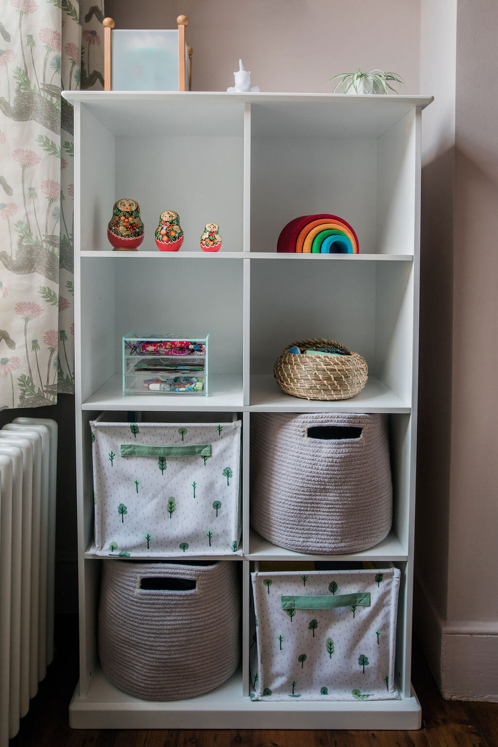 White cube shelving unit with ornaments and insert bins