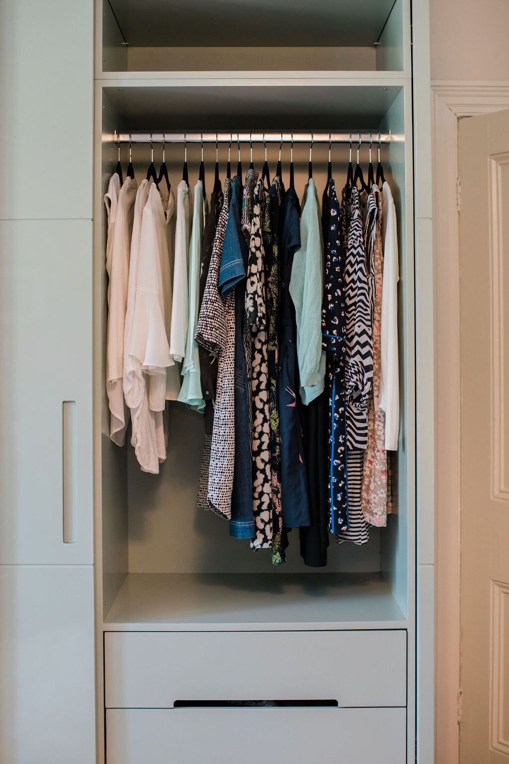 Wardrobe with clothes organised by colour