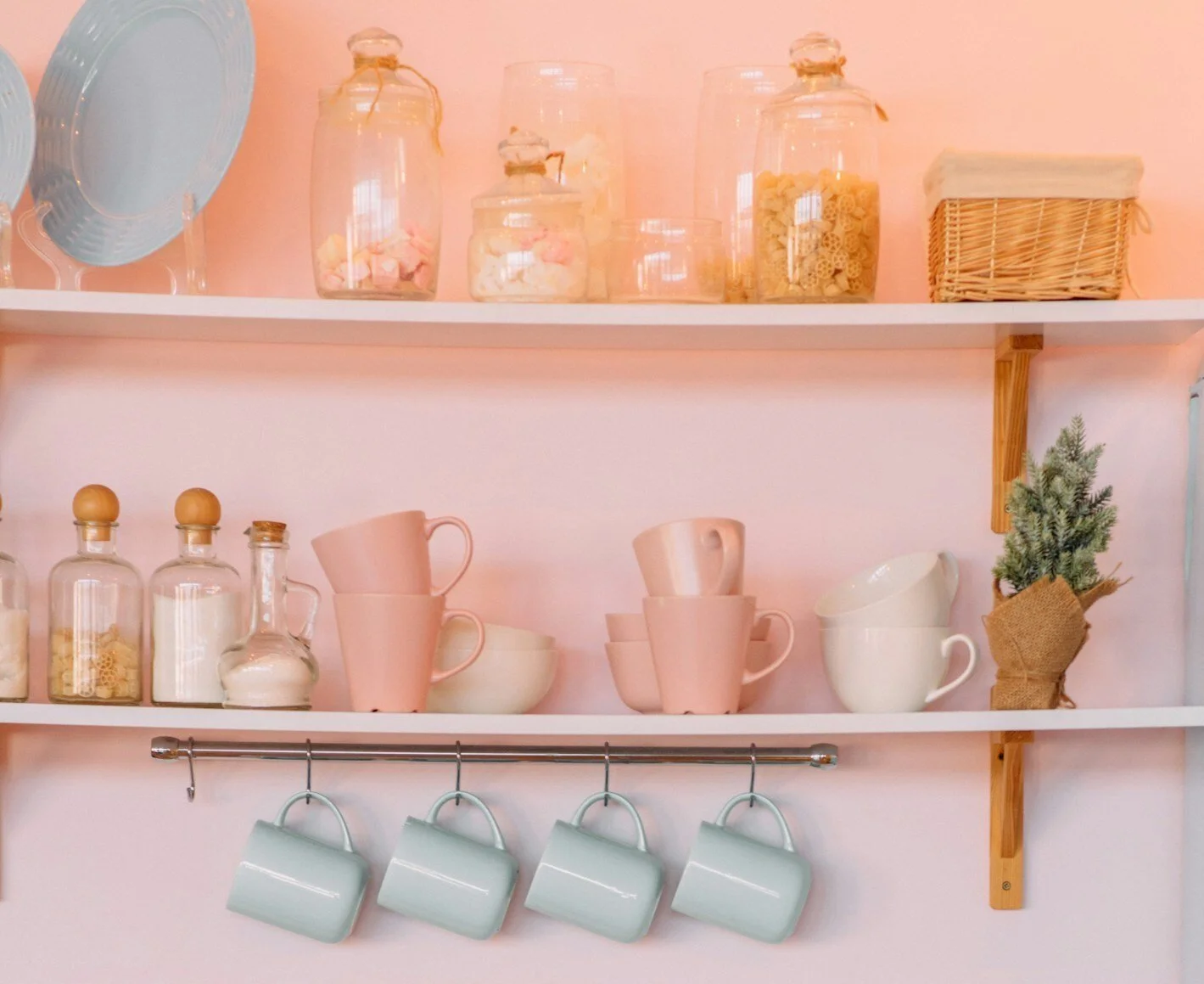 open kitchen shelving with mugs and glass cannisters holding dried goods