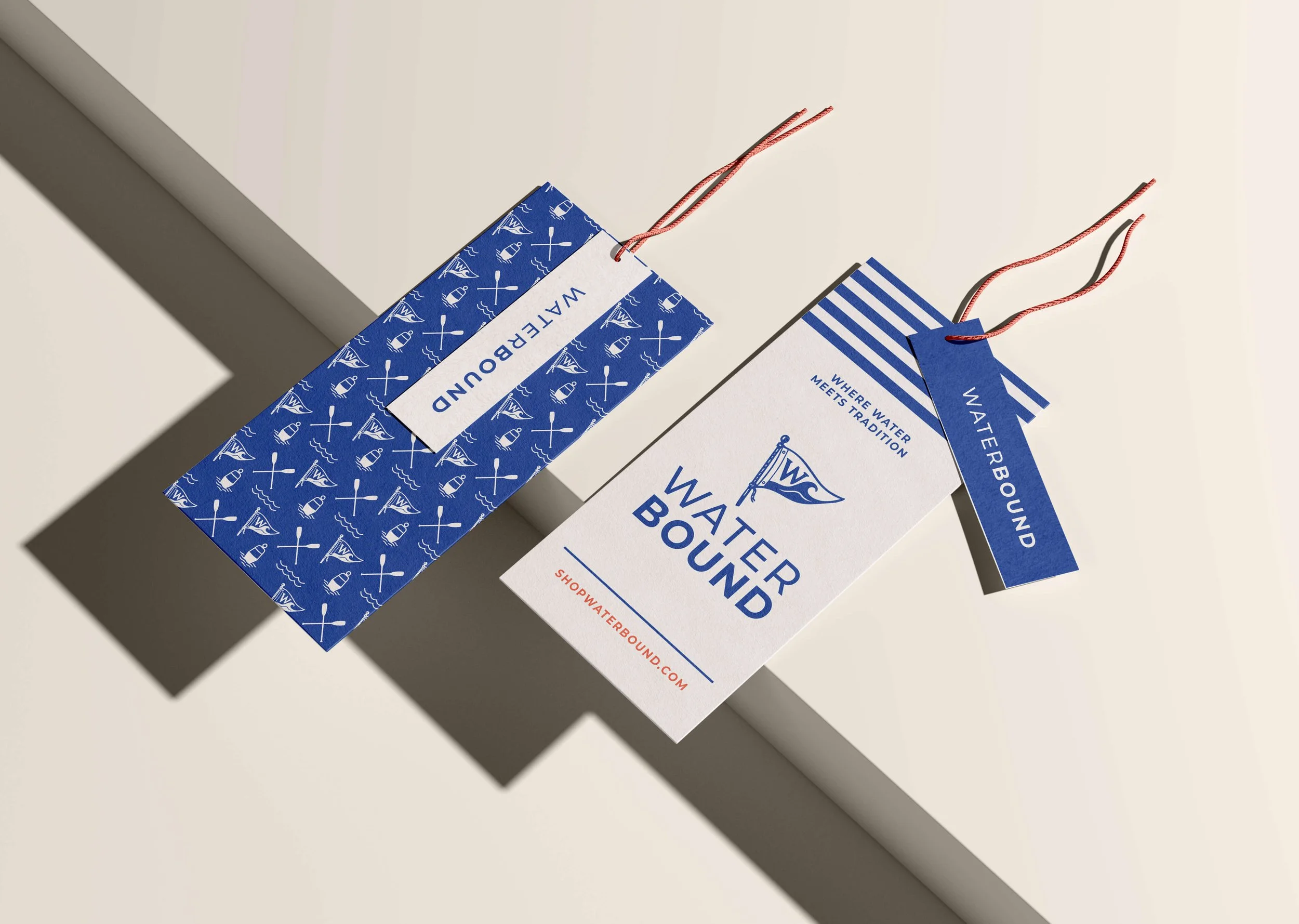Waterbound clothing & hang tags with blue and white nautical designs and red string.