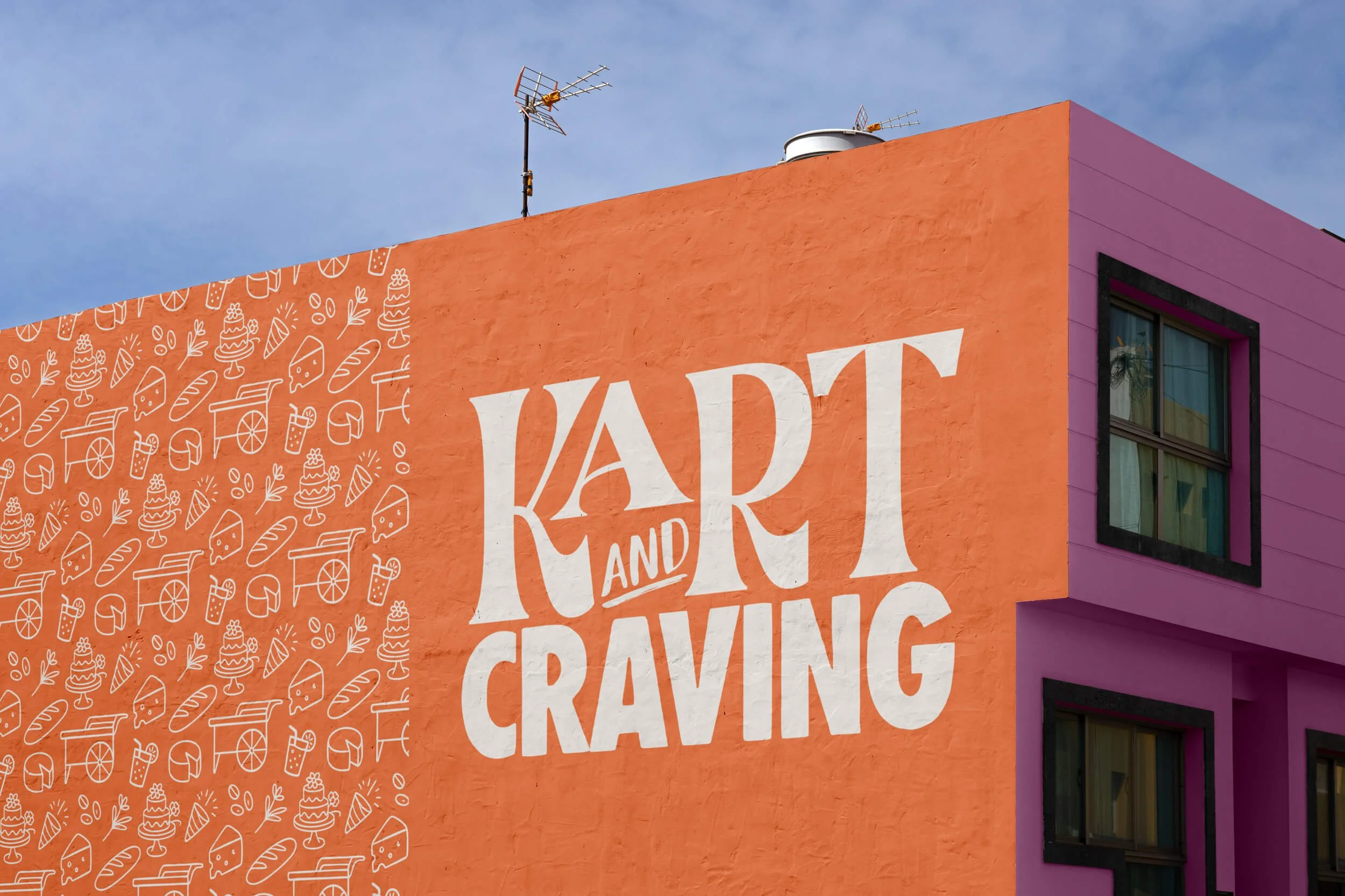 Close-up of a colorful building featuring a large sign that reads "Kart and Craving." The building has an orange wall with white illustrations of food the company serves.