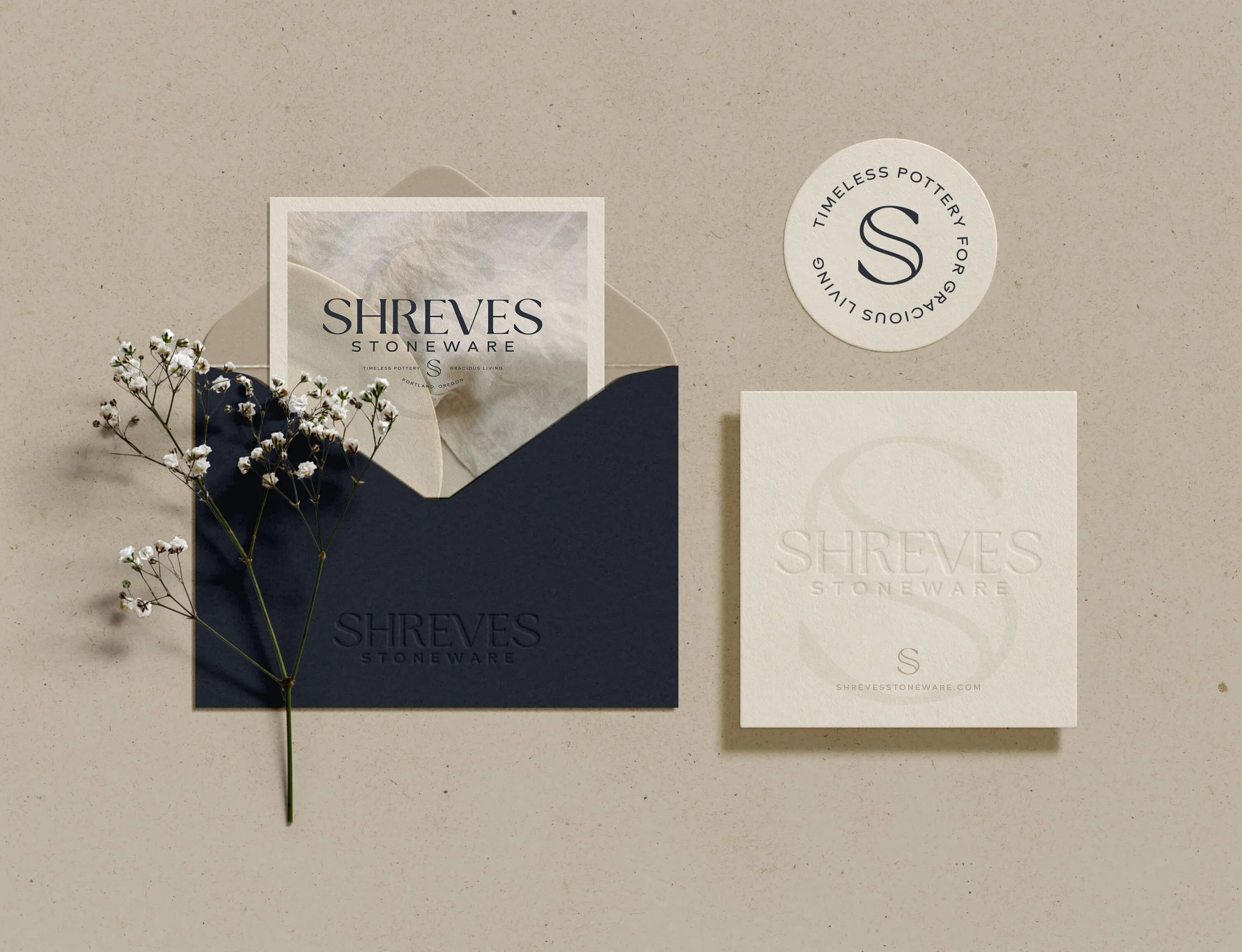A flat lay of branding materials from Shreves Stoneware, including business cards, envelopes, and sticker.
