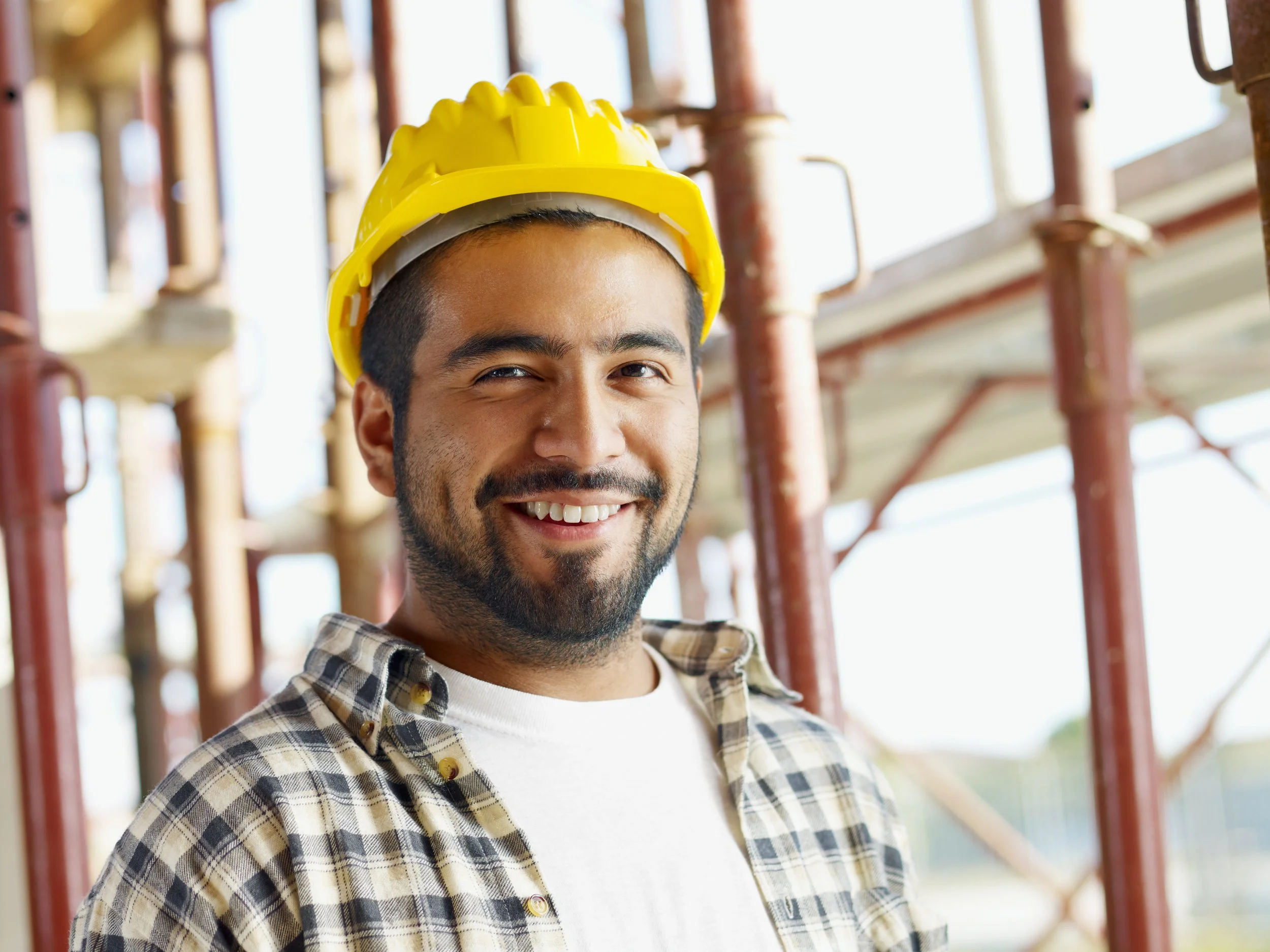 un hombre latino trabajando en la construcción sonriendo