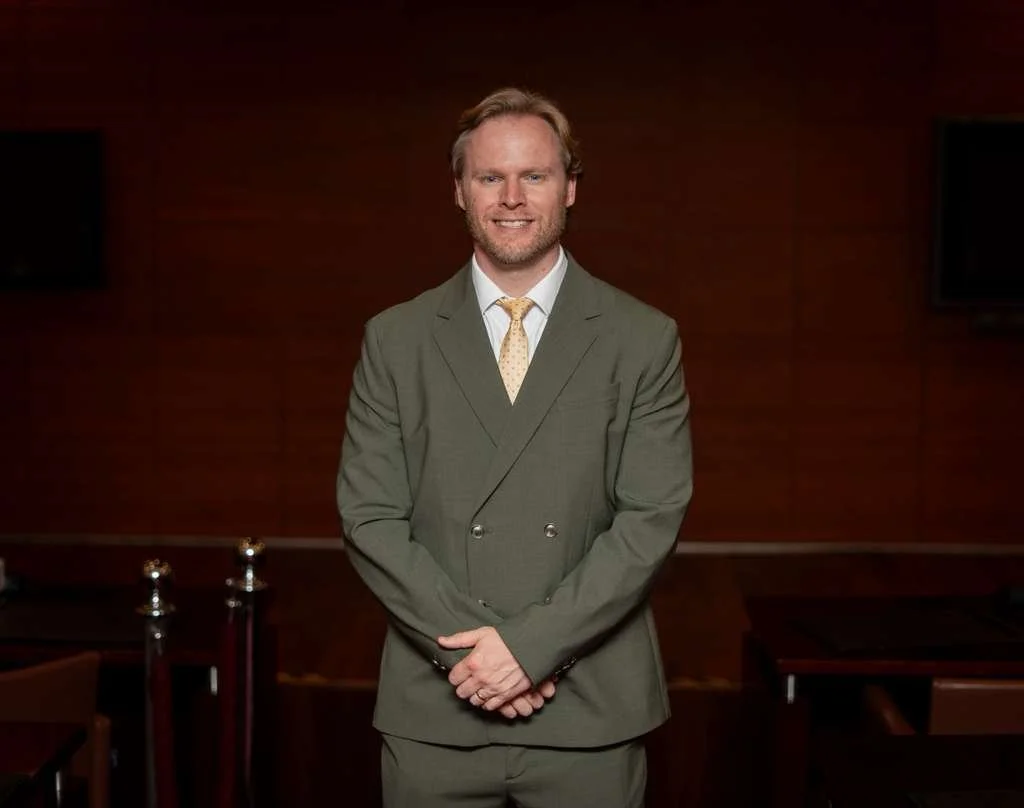 Una foto del ex cónsul Brent Hansen, posando con traje.