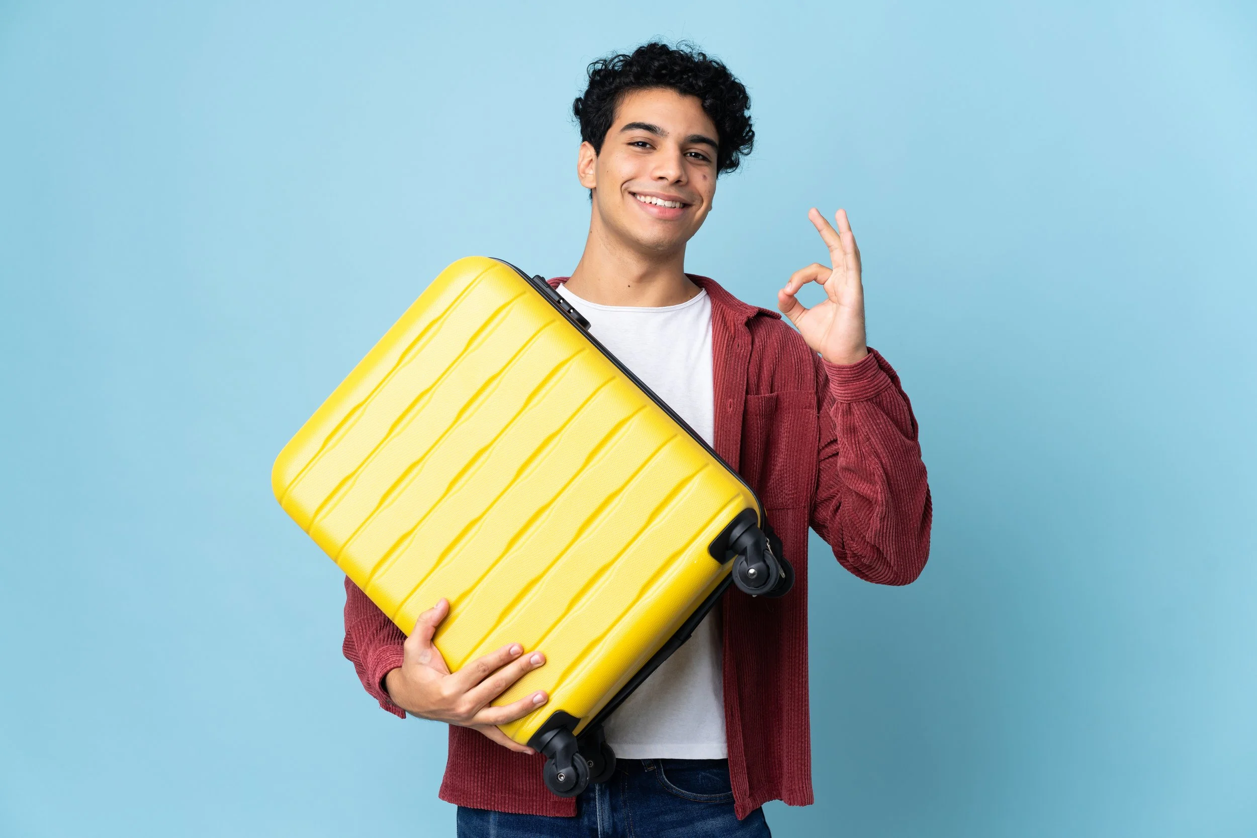 Hombre latino que lleva su equipaje mientras se prepara para viajar.