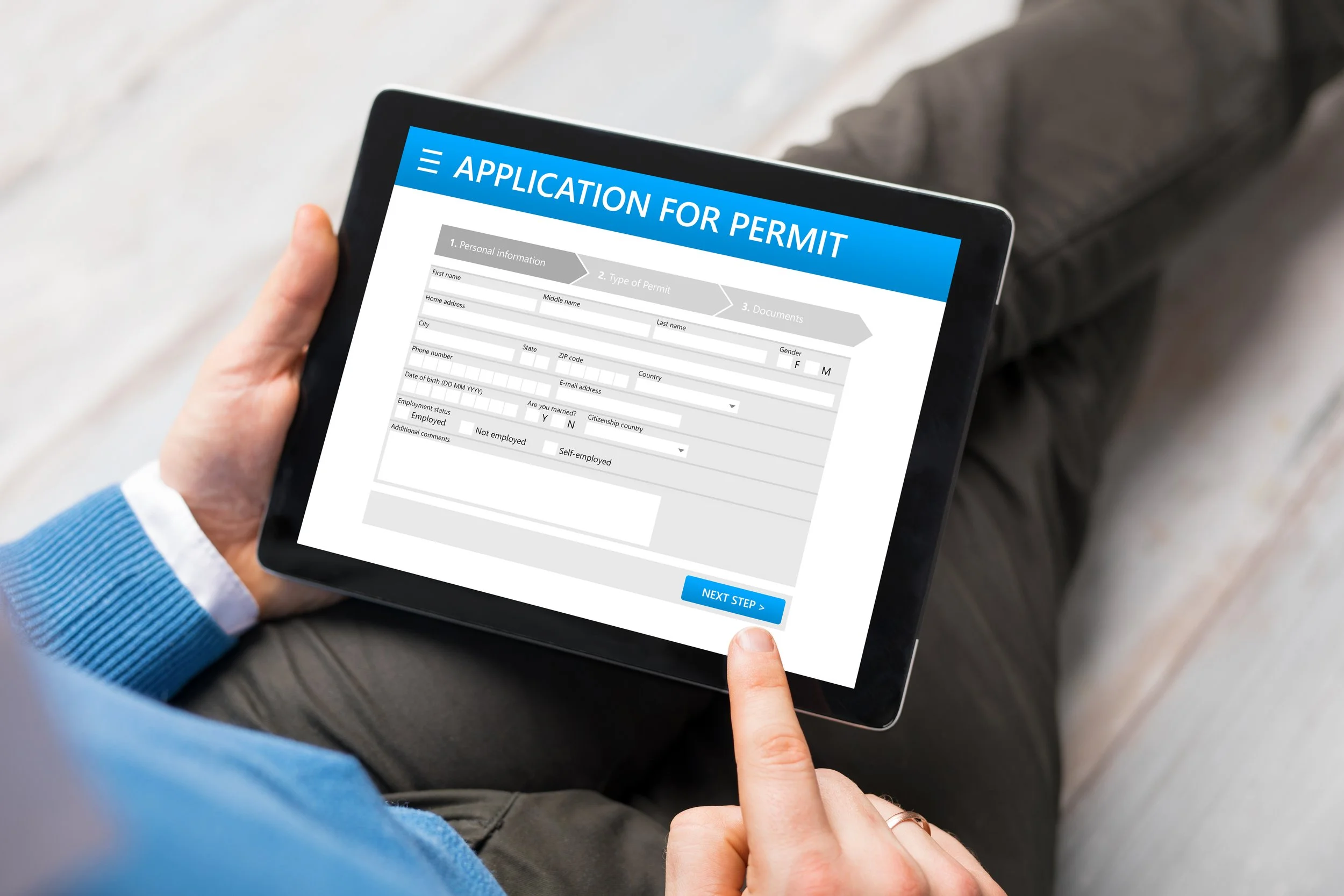 Un hombre usando una tableta para completar un formulario y programar su cita para la visa.