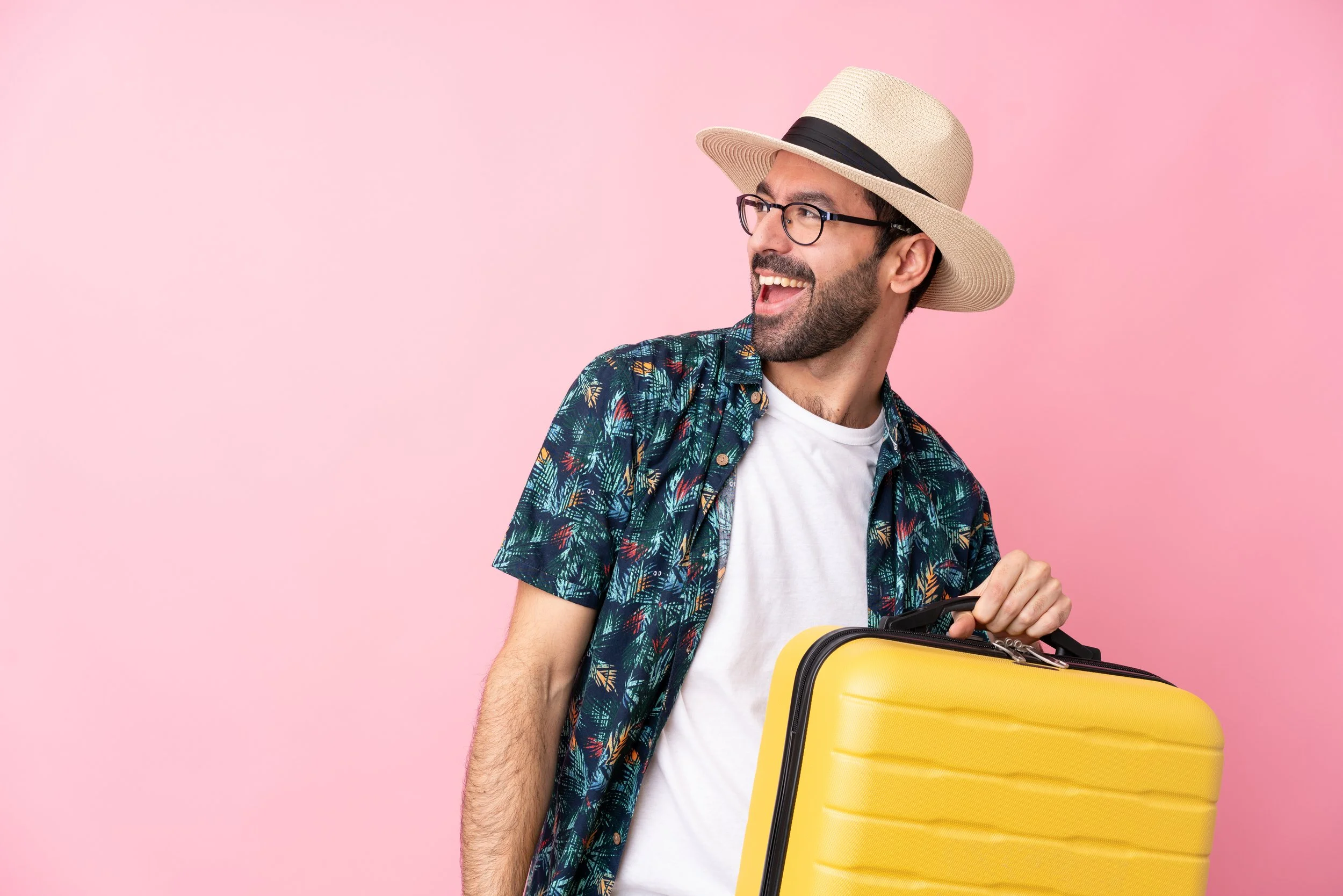 Hombre guatemalteco sonriendo mientras sostiene su equipaje y se prepara para viajar.