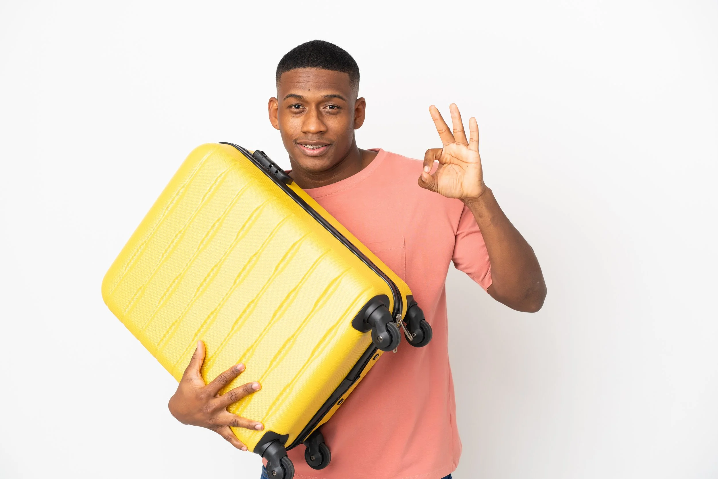 Hombre dominicano sonriente que sostiene su equipaje mientras se prepara para viajar.