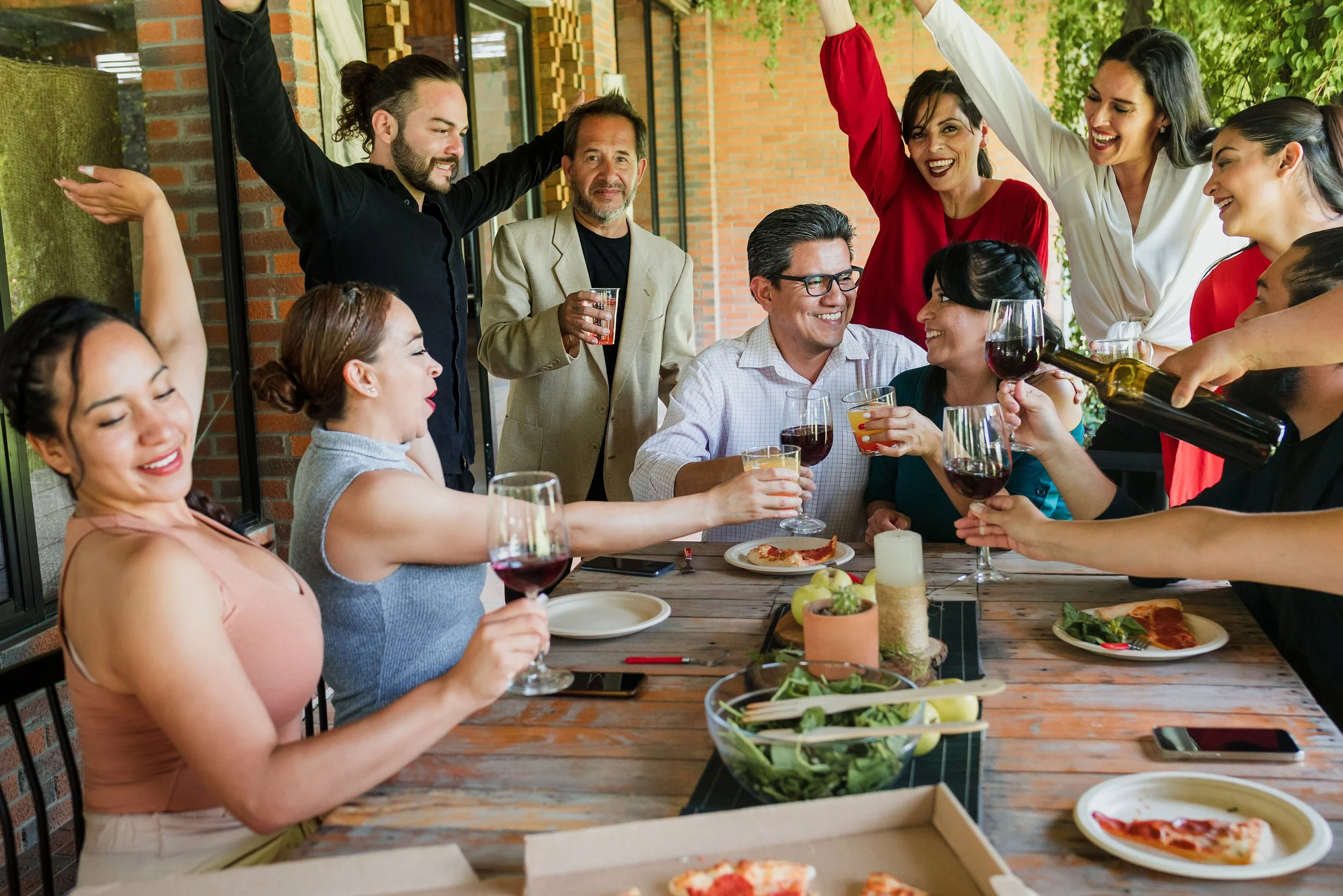 Una gran familia se reúne y comparte una comida.