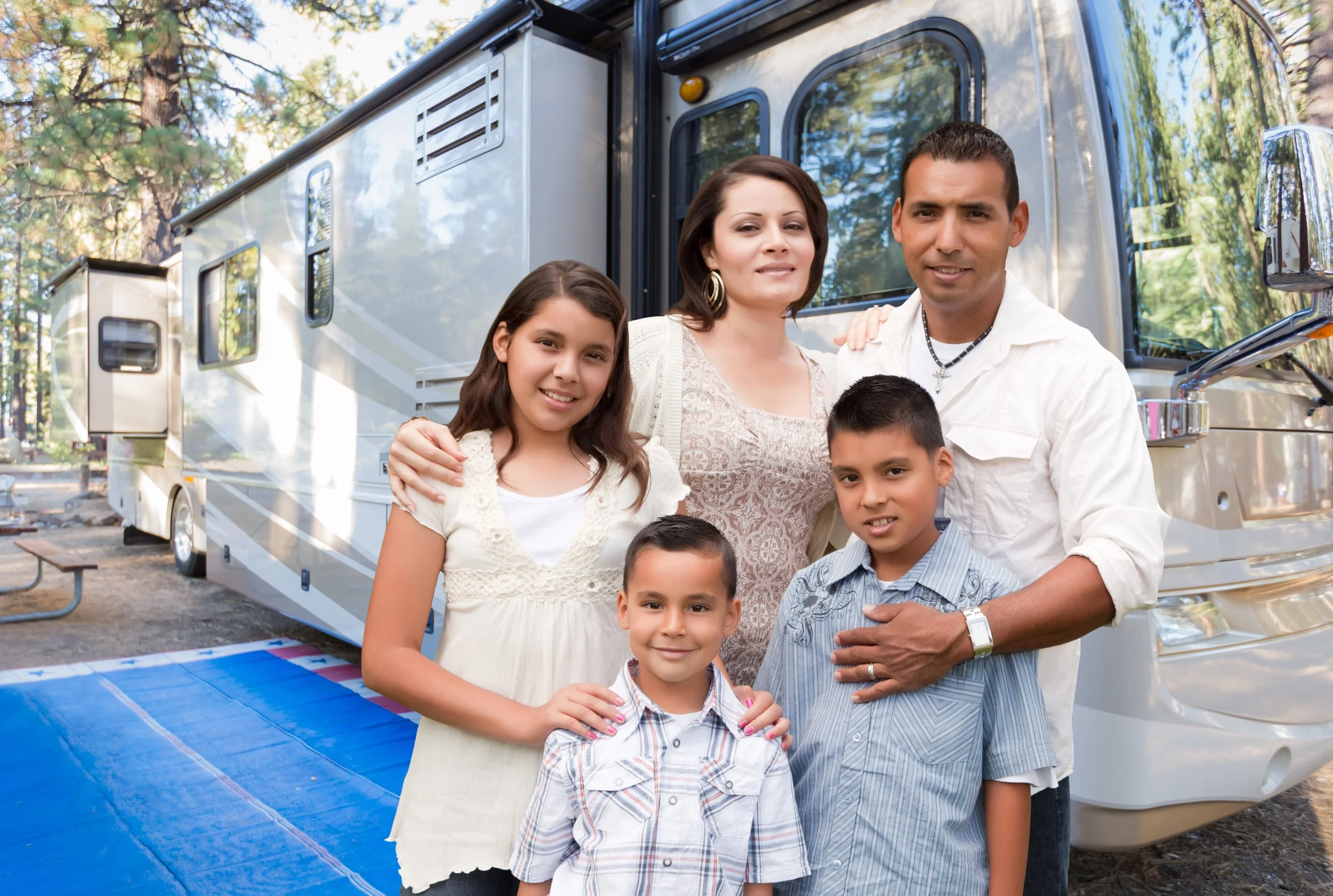 Una familia mexicana [posando frente a su casa rodante mientras viajan por los Estados Unidos]