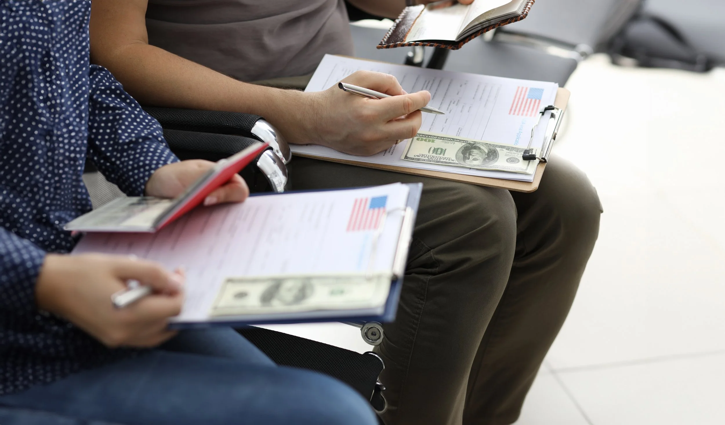 Personas sentadas, esperando para pagar su visa estadounidense.