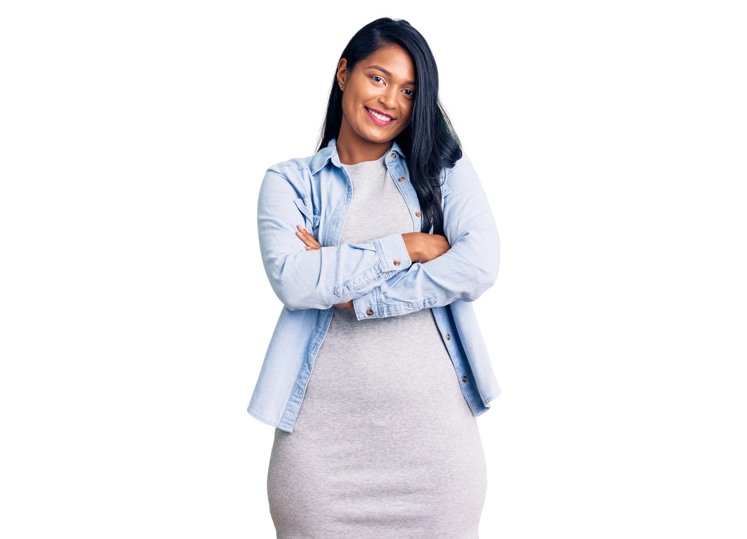 Una mujer sonriente y con los brazos cruzados viste ropa de estilo *business casual* mientras espera su cita para la visa.