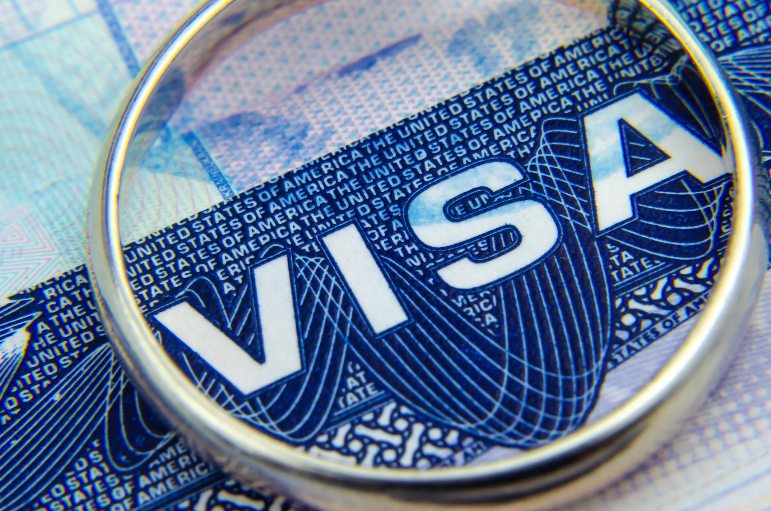 Una lupa enfocando de cerca una visa de EE. UU.