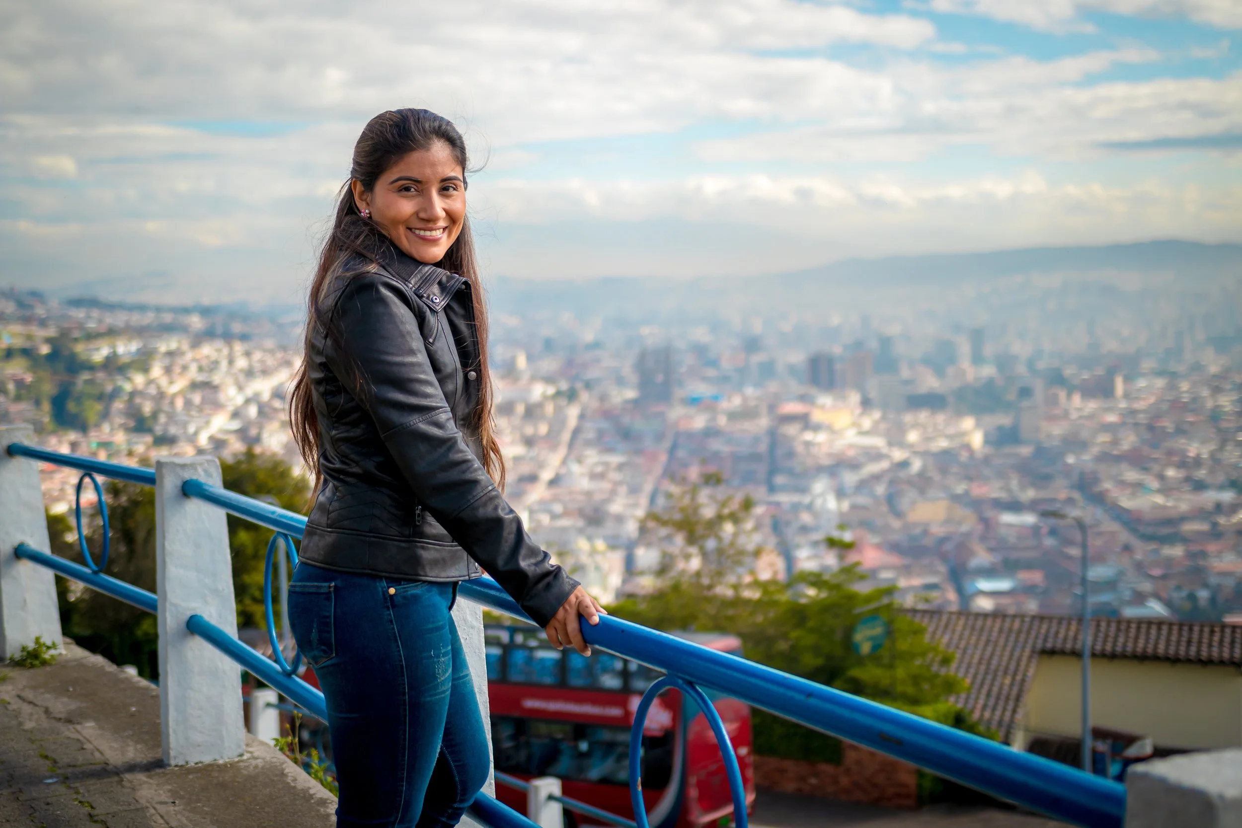 La mujer salvadoreña que posa en un mirador disfrutando de sus viajes.