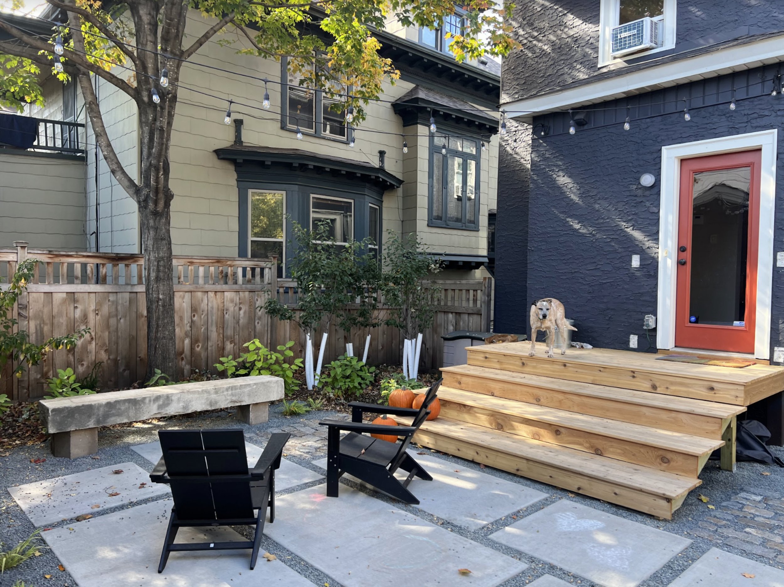 Urban backyard, modern landscape, concrete slabs, stone bench, lounge chair, cedar deck