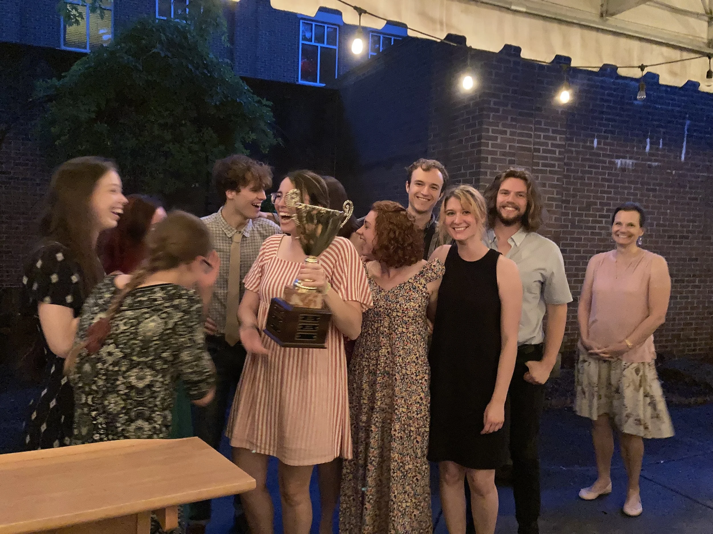 A group of classical students holding the house cup outside.