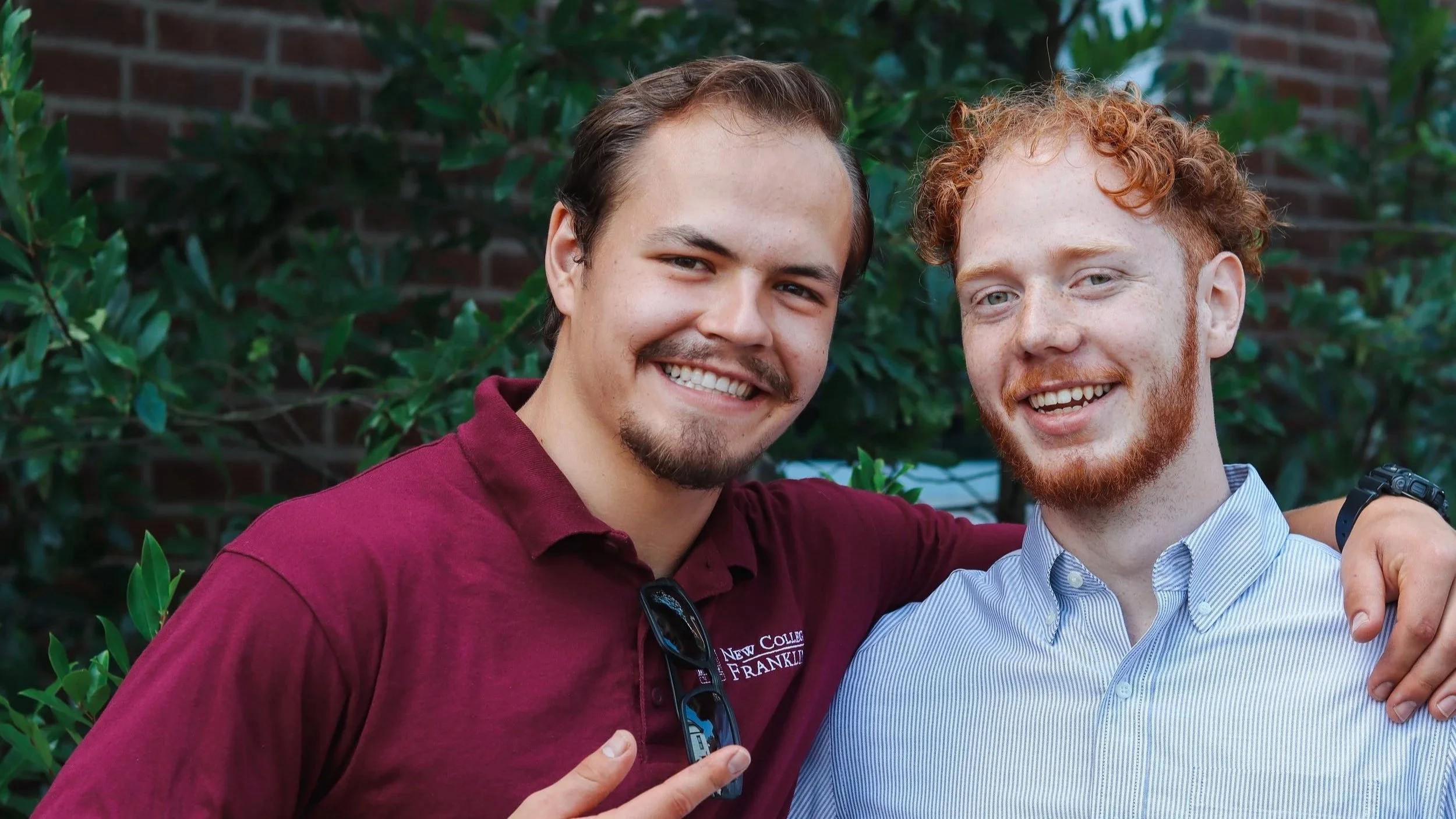 Two college students from a liberal arts school standing outside.