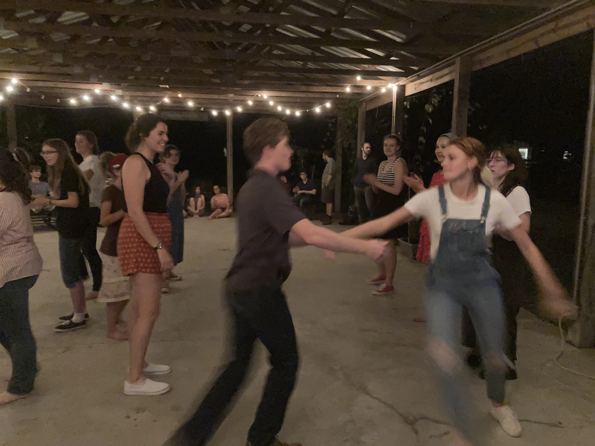 Students from a small Christian school dancing outside under a pavilion.