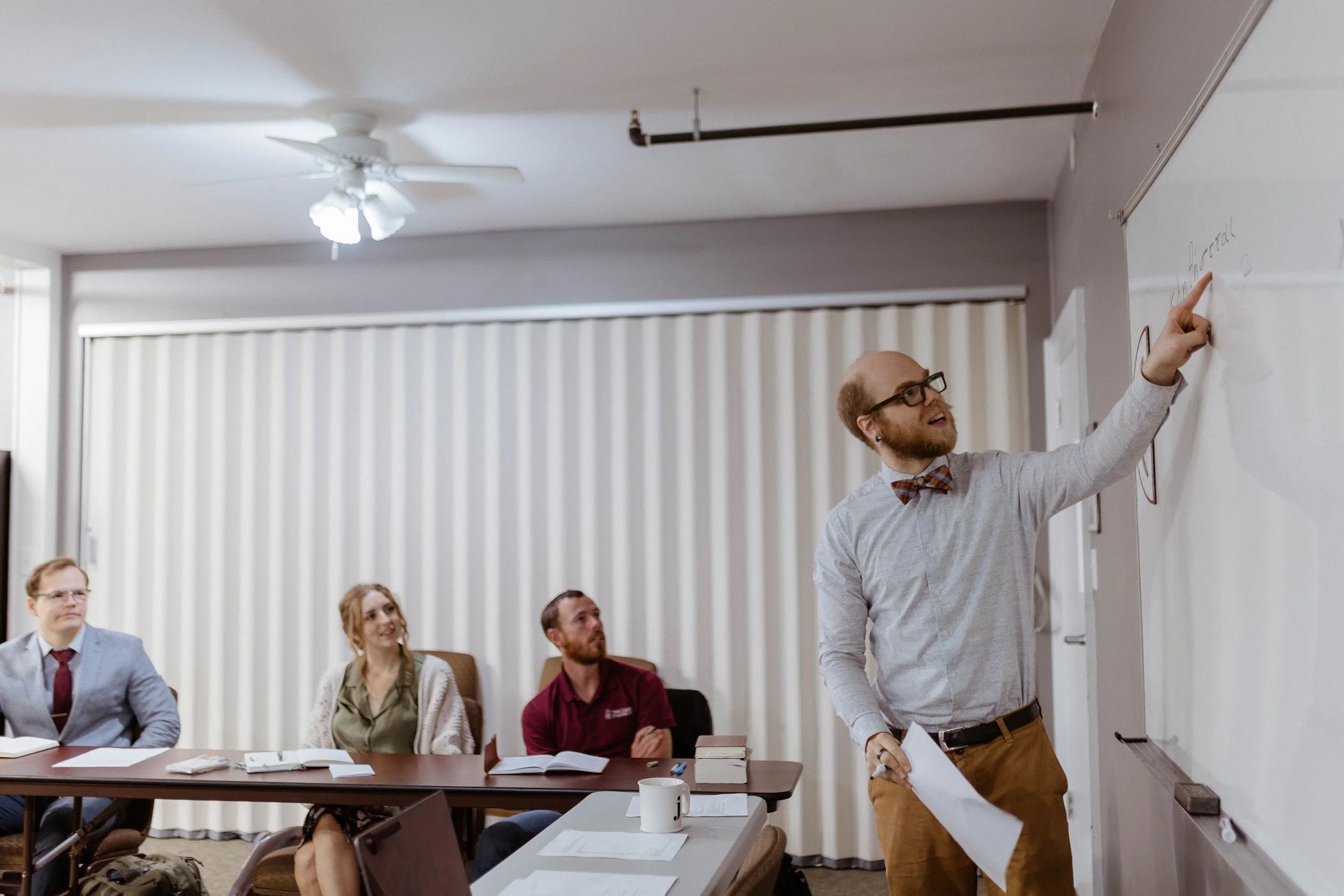 Man with glasses and beard teaching in a classical school, representing a course in the Trivium.