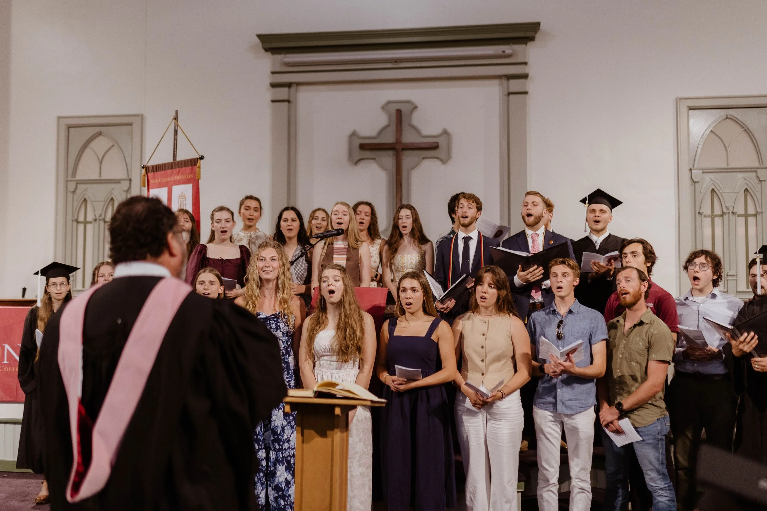 A group of choir singers from a Christian school singing on stage.