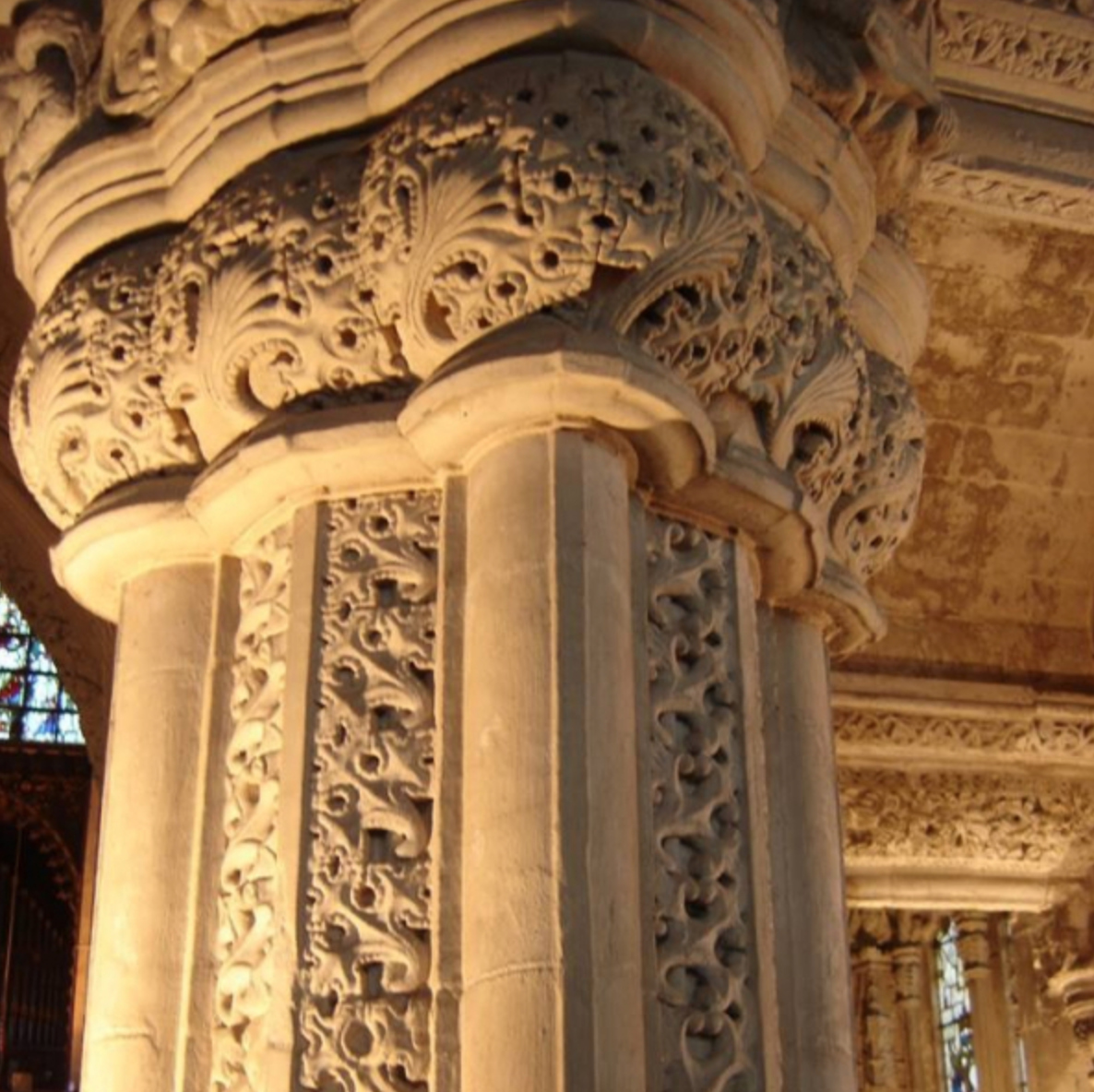 Intricate stone carving on a church column with floral and geometric patterns, representing a course in a liberal arts education.