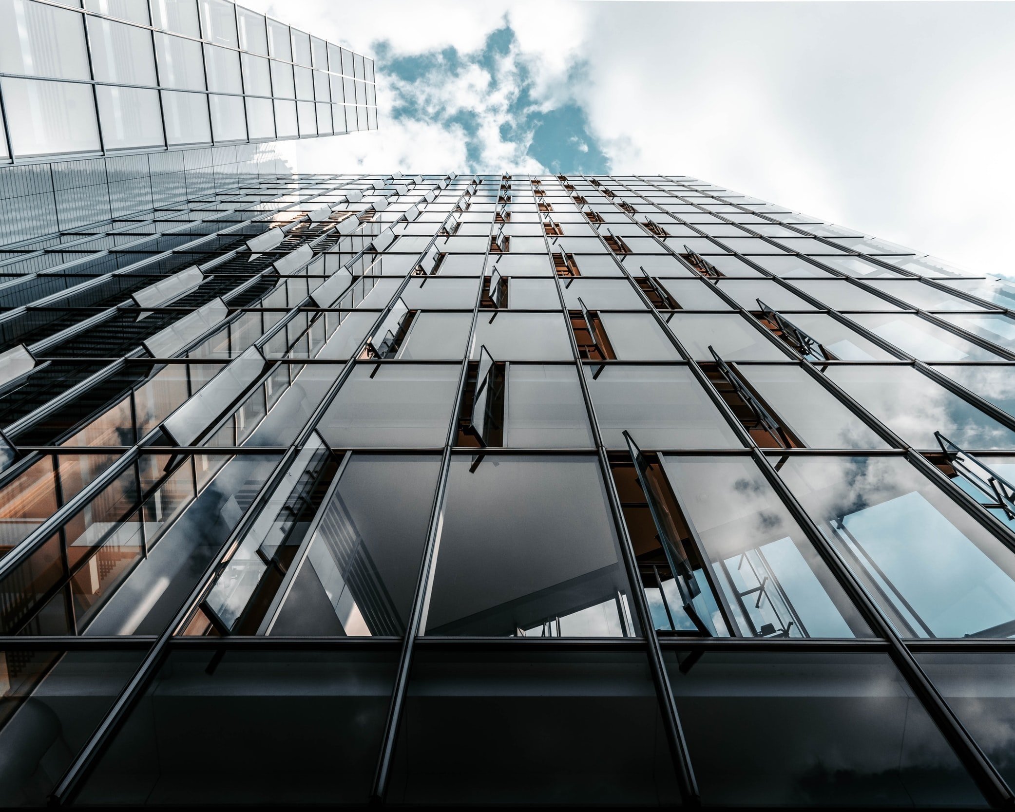 View from the base of large corporate building looking all the way up to the sky, it represents the big home loan lenders and the importance of understanding how your home loan application be assessed.