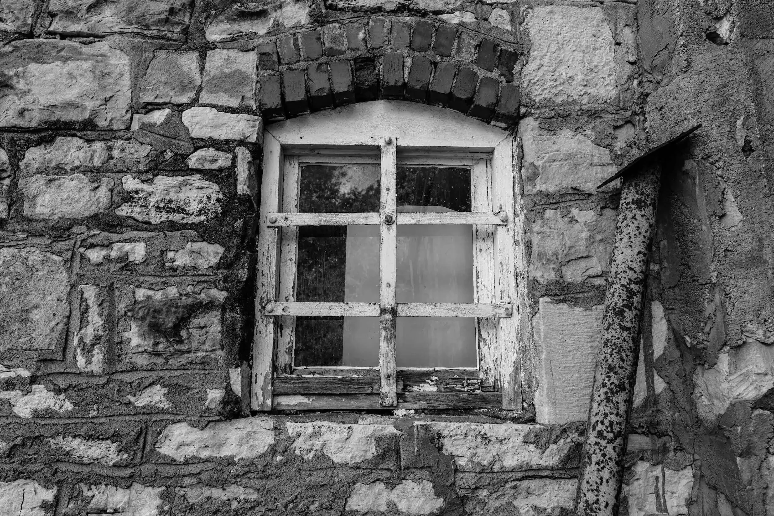 An older style window in back and white, it needs significant repair due to ageing, it represents the importance of conducting a pest and building report when buying property.