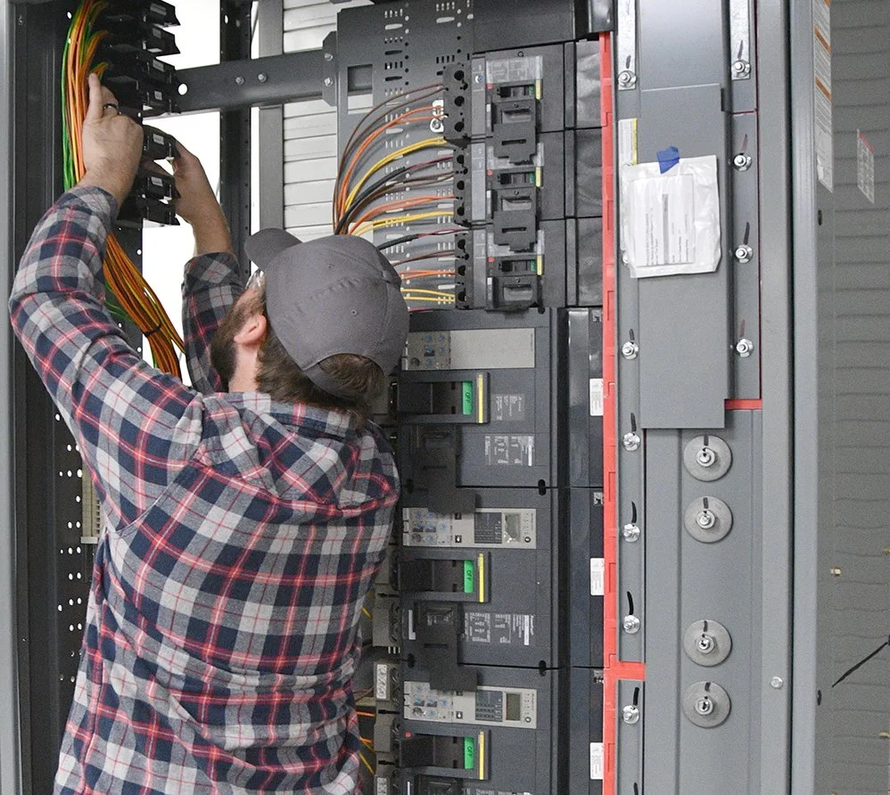- Technician installing and wiring a custom UL891 low voltage electrical switchboard