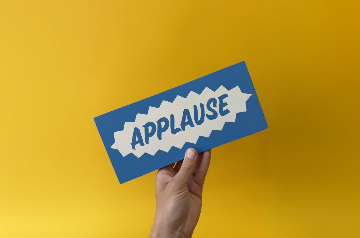 Bold and colourful Applause sign being held up proudly