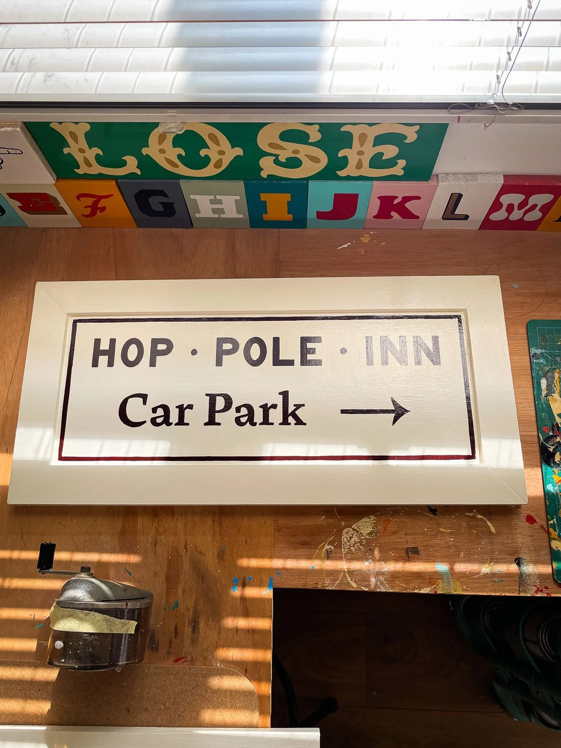 Hand-painted signage for the Hop Pole Inn in Limpley Stoke featuring brand logo, lettering and custom frames, showcasing the craftsmanship of Rich C Studio.