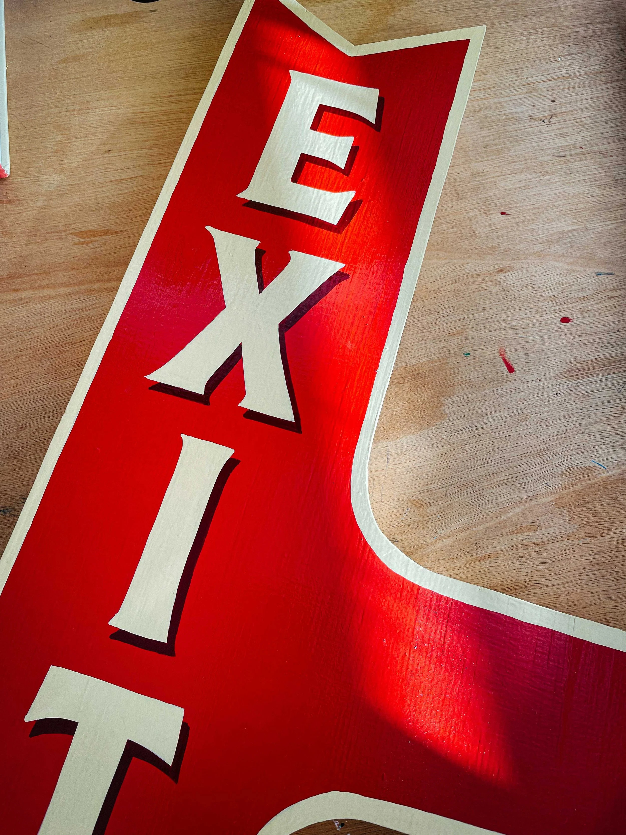 A hand-painted sign featuring bold, custom lettering in vibrant colours, showcasing the craftsmanship of Rich C Studio.