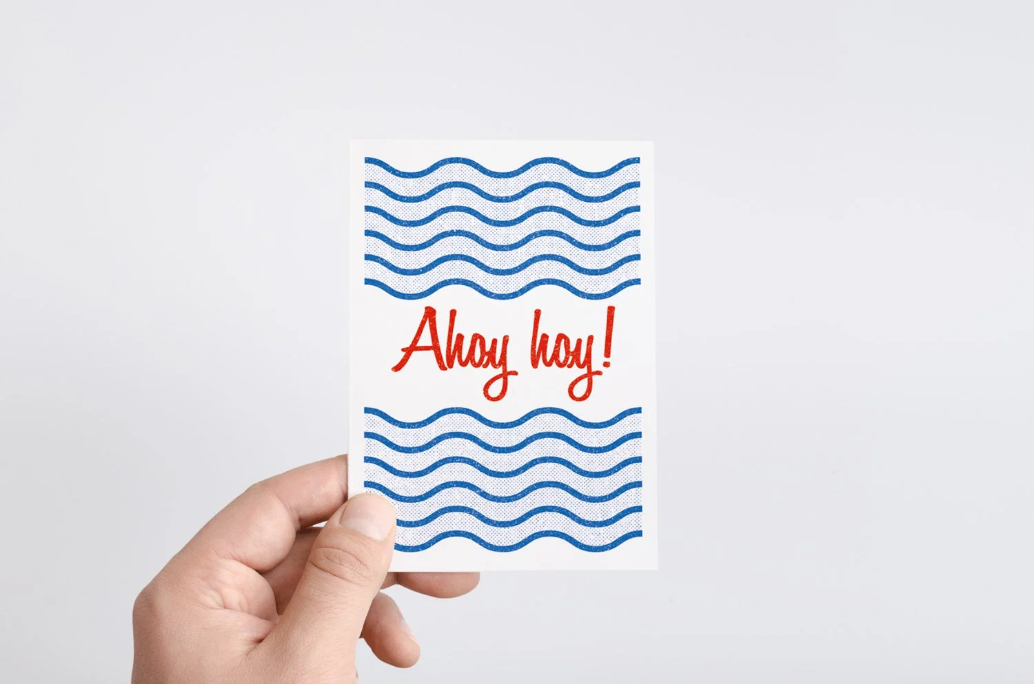 Hand holding card with "Ahoy hoy!" text and blue wave design.