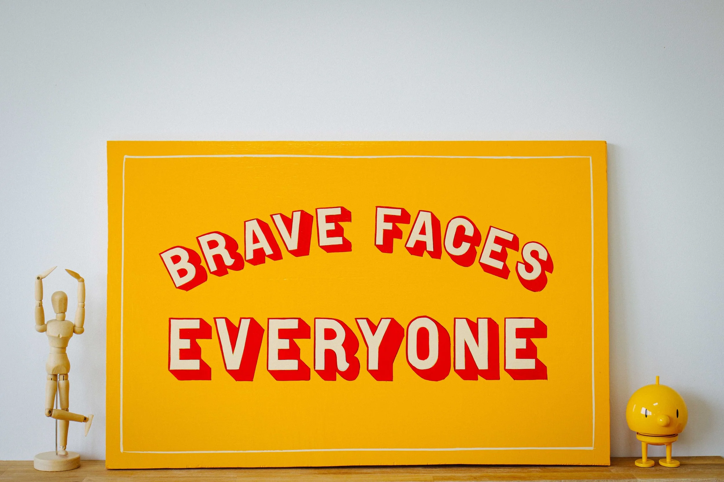 A hand-painted sign featuring bold, custom lettering in vibrant colours, showcasing the craftsmanship of Rich C Studio.