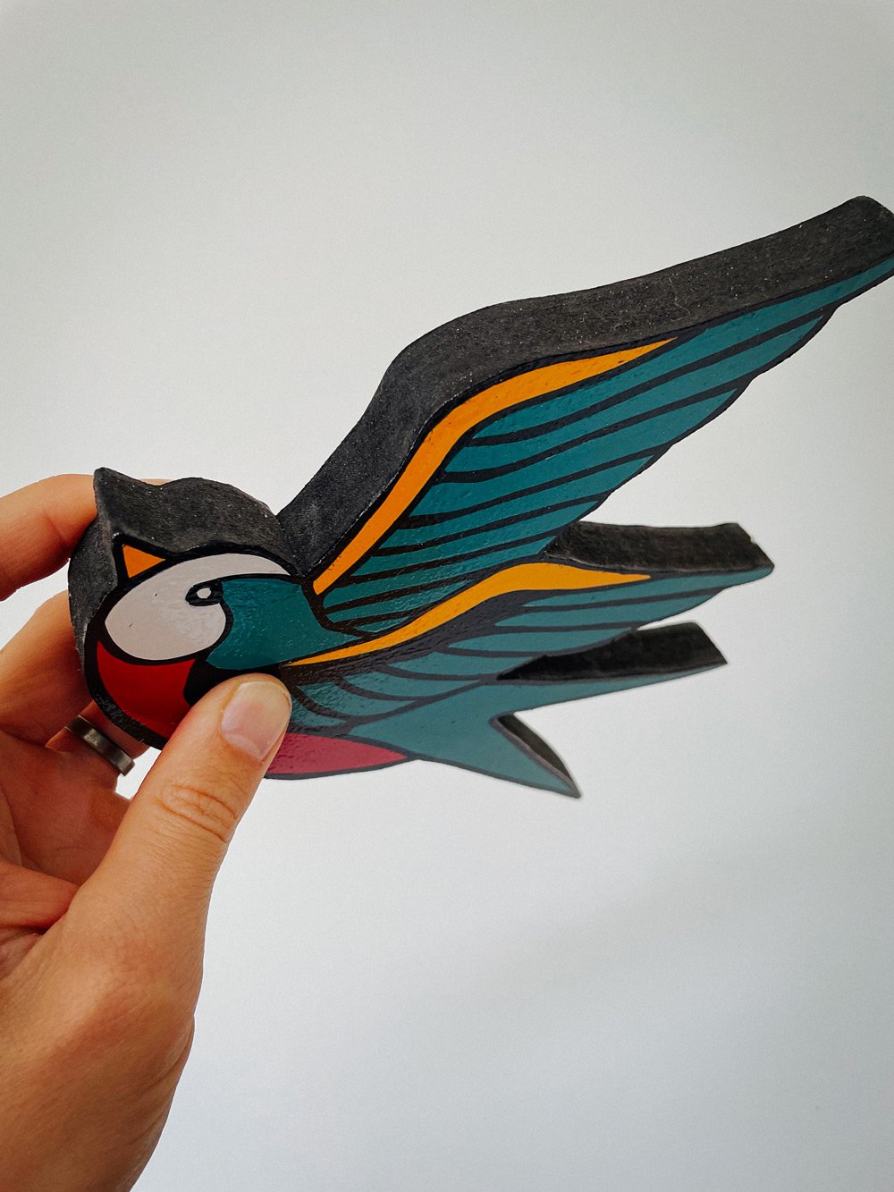 Hand-painted woodcut of swallows in flight, showcasing smooth brushstrokes and delicate details. The design captures movement and freedom with vibrant colours and skilled craftsmanship.