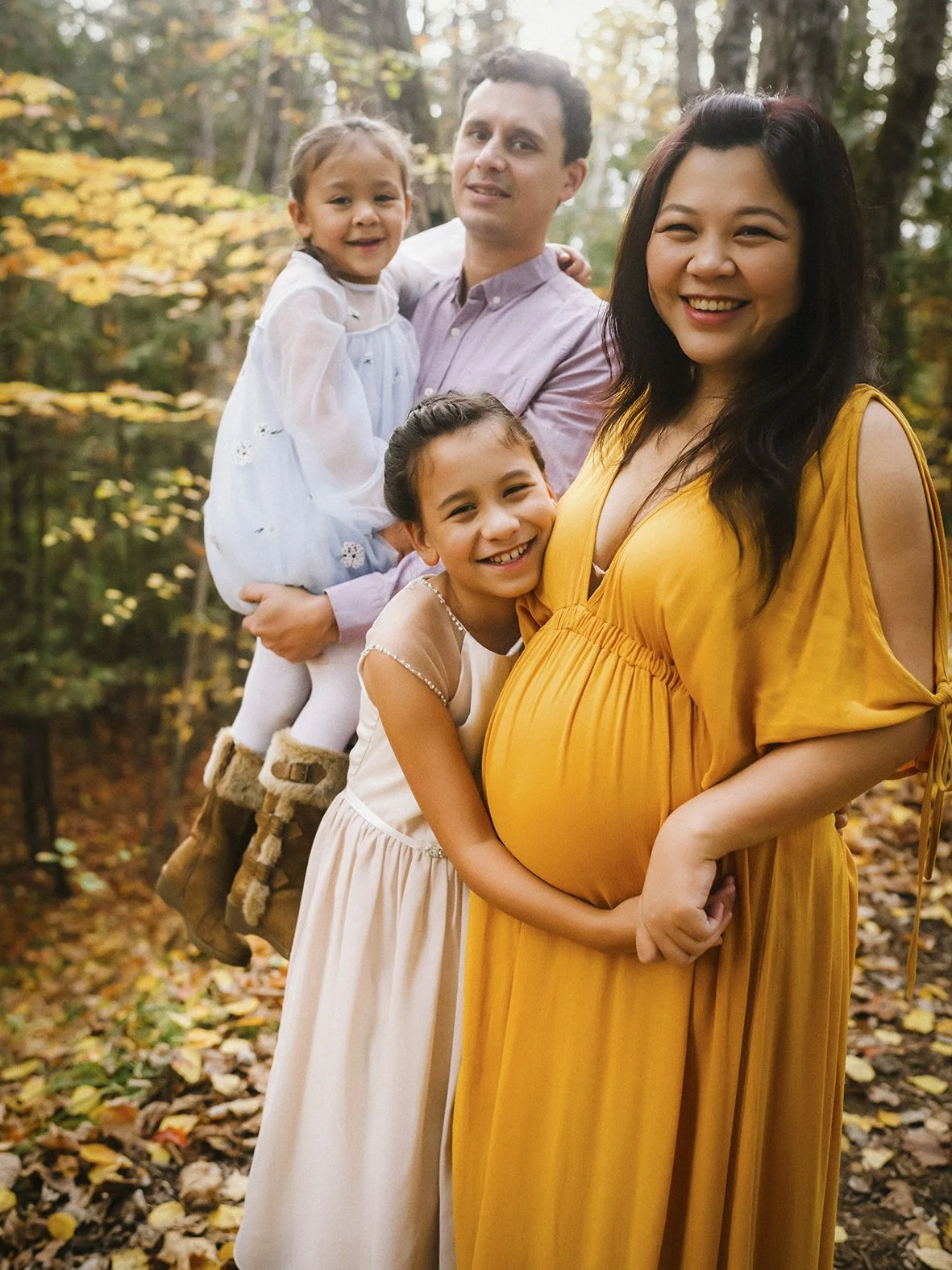 pregnant woman, her two daughters, and her husband were in the autumn forest