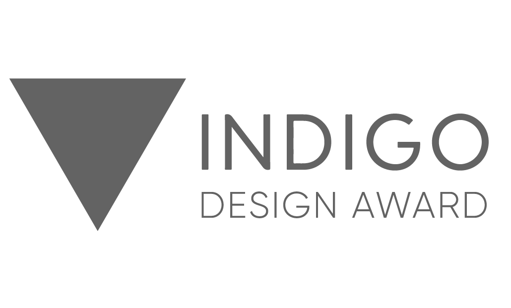 Indigo Design Award logo featuring a grey downward-pointing triangle to the left of the words 'INDIGO DESIGN AWARD' in grey and white text.
