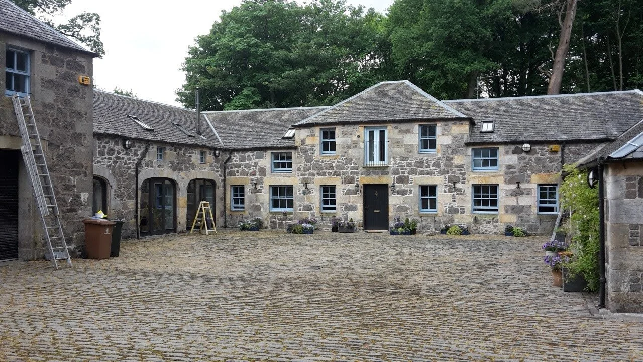 Historic stone courtyard with two-story building, 
