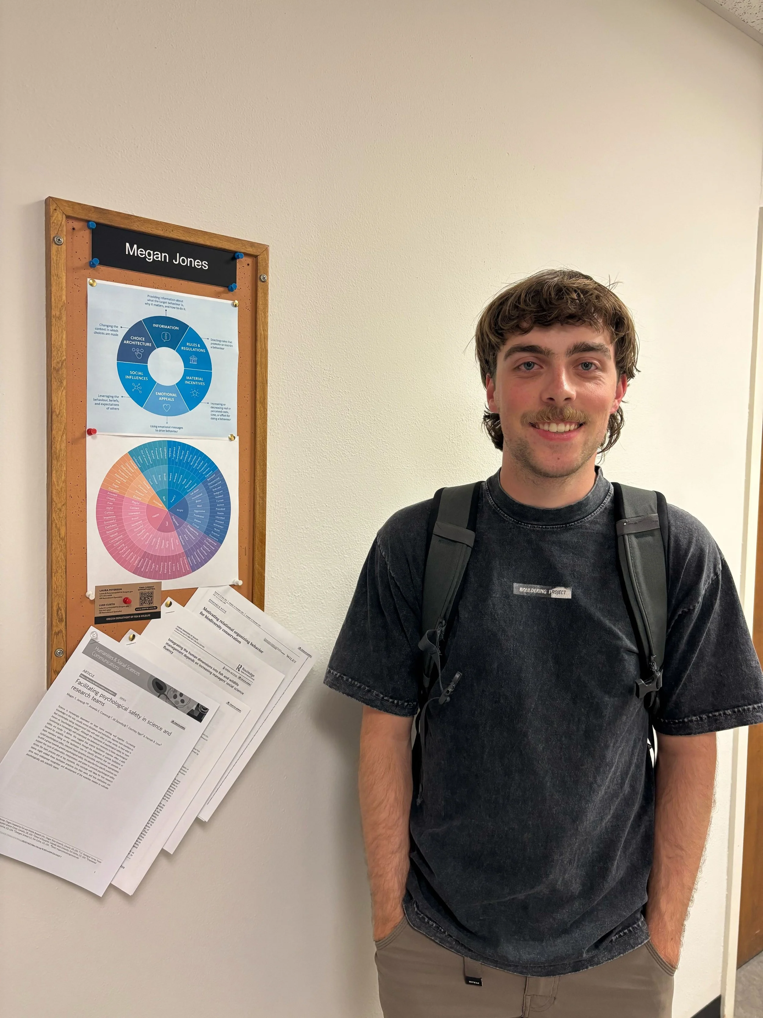 Daniel standing in front of Megan's office