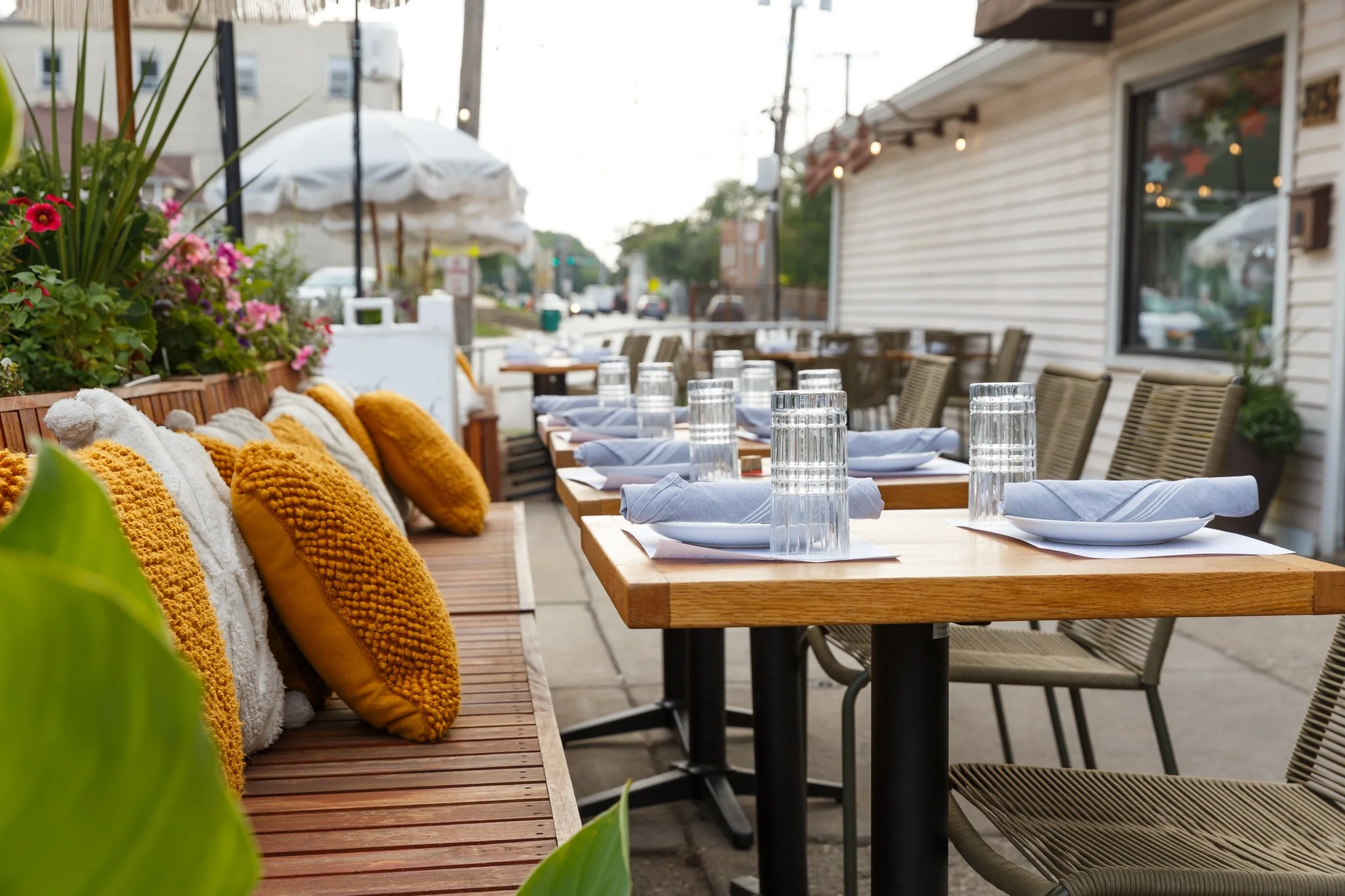 A photo of the Wooden Paddle patio with benches, cushions, chairs, and two-tops in Lemont, Illinois.