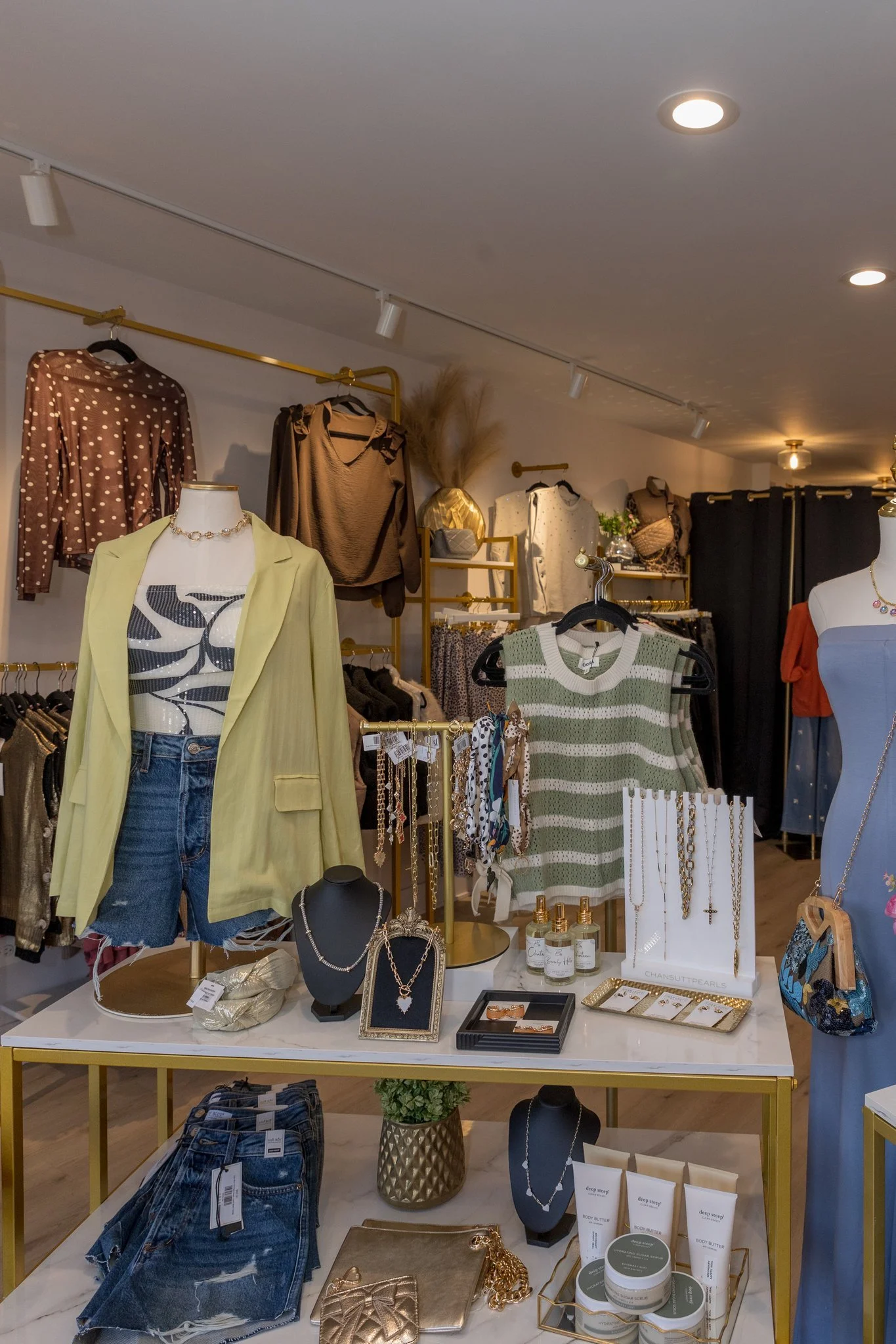 A photo of green and red sweaters, cardigans, bottoms, pants, tops, and jewelry available at Jaclyn Sue Boutique in Lemont Downtown, Illinois.