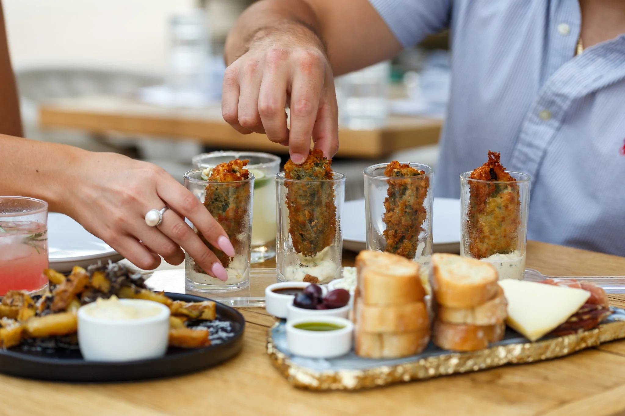 A photo of menu offerings available at Wooden Paddle in Lemont, Illinois. Wings, bread and cheese, cocktails are being enjoyed on the Wooden Paddle patio.