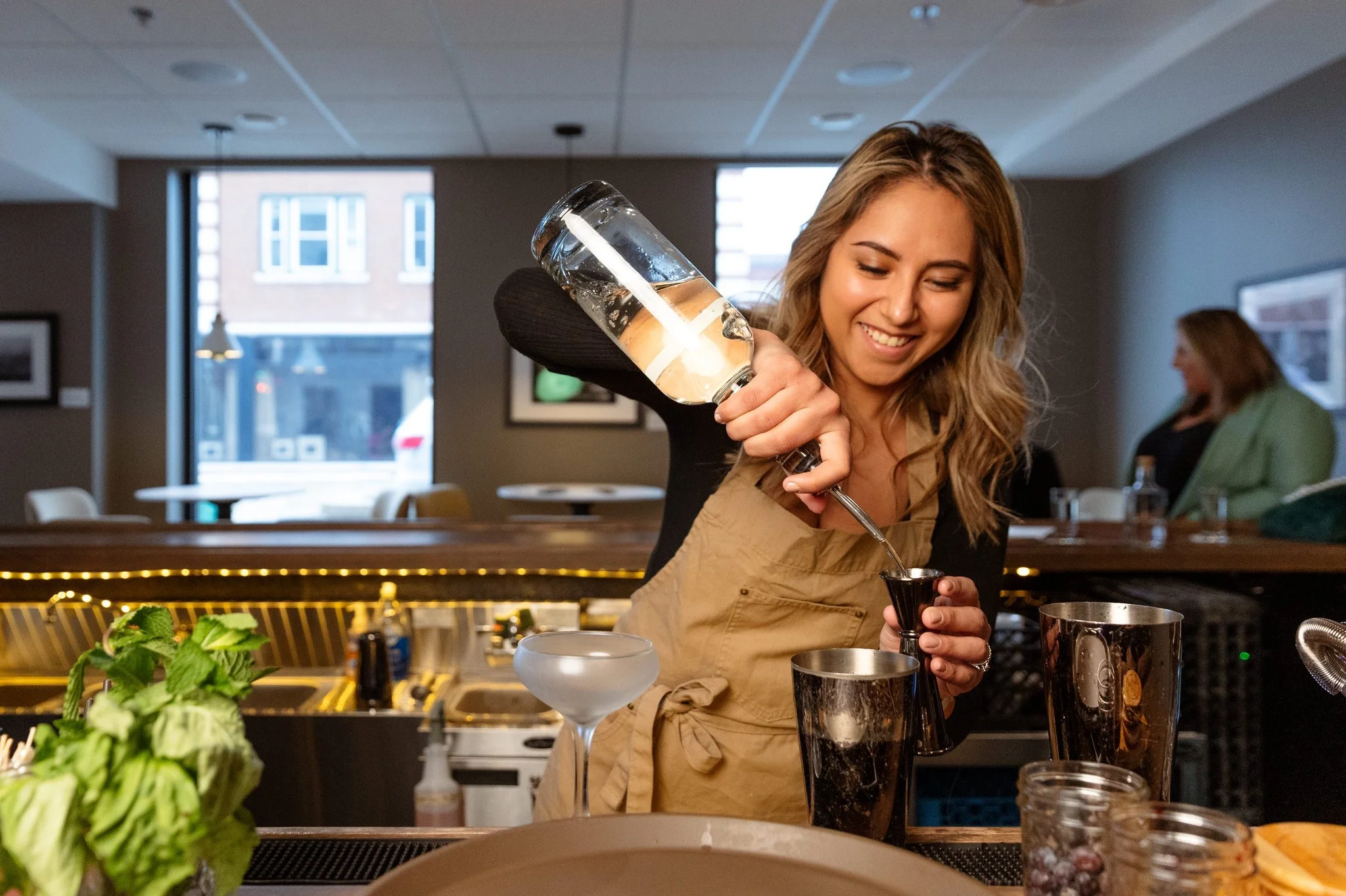 A photo of a bartender preparing a cocktail at Pollyanna Social in Lemont Downtown, Illinois.