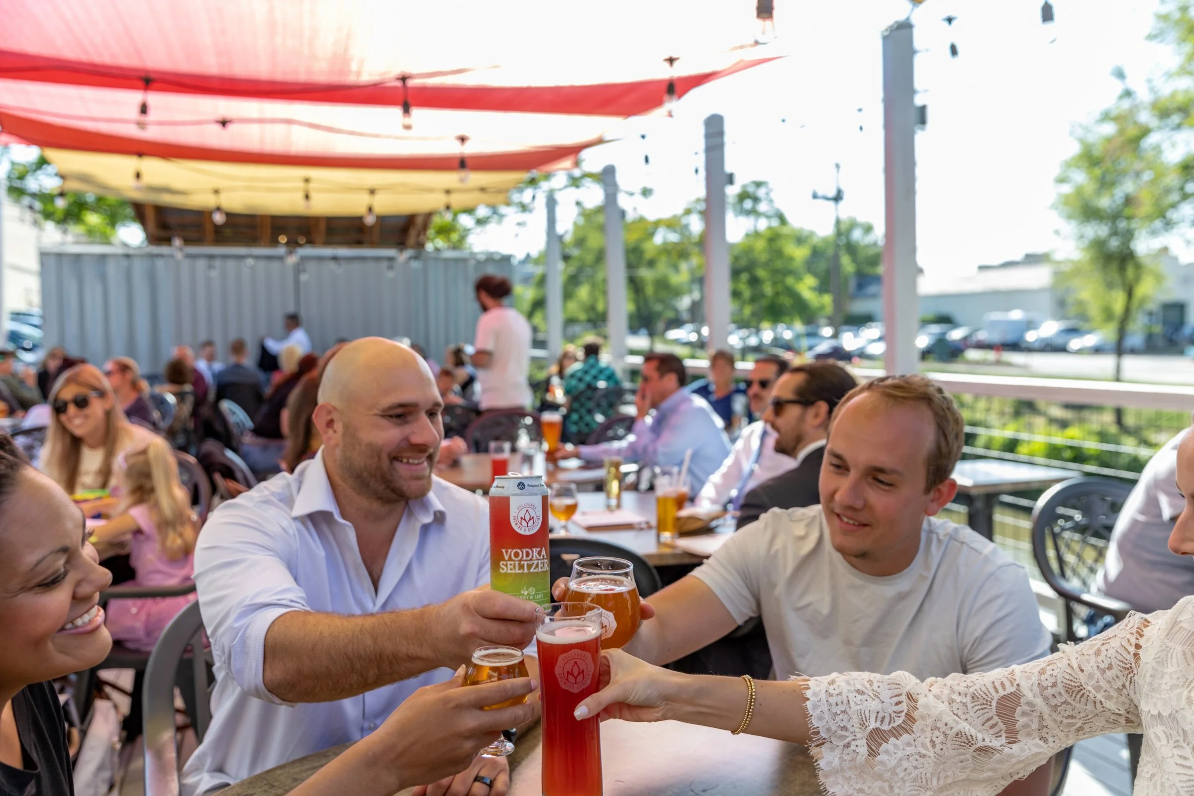 A photo of four friends and craft beer enthusiasts at the beer garden at Pollyanna Brewing Company in Lemont Downtown, Illinois.
