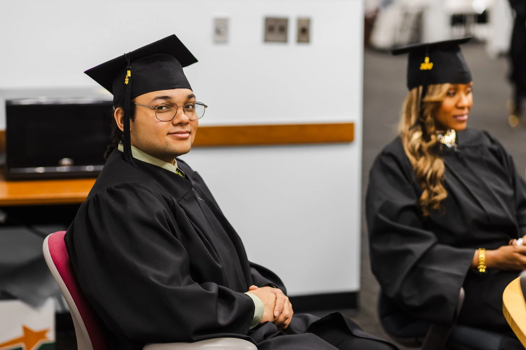 A man smiling at the camera in graduation gear: nonprofit graduation ceremony Detroit event photography.