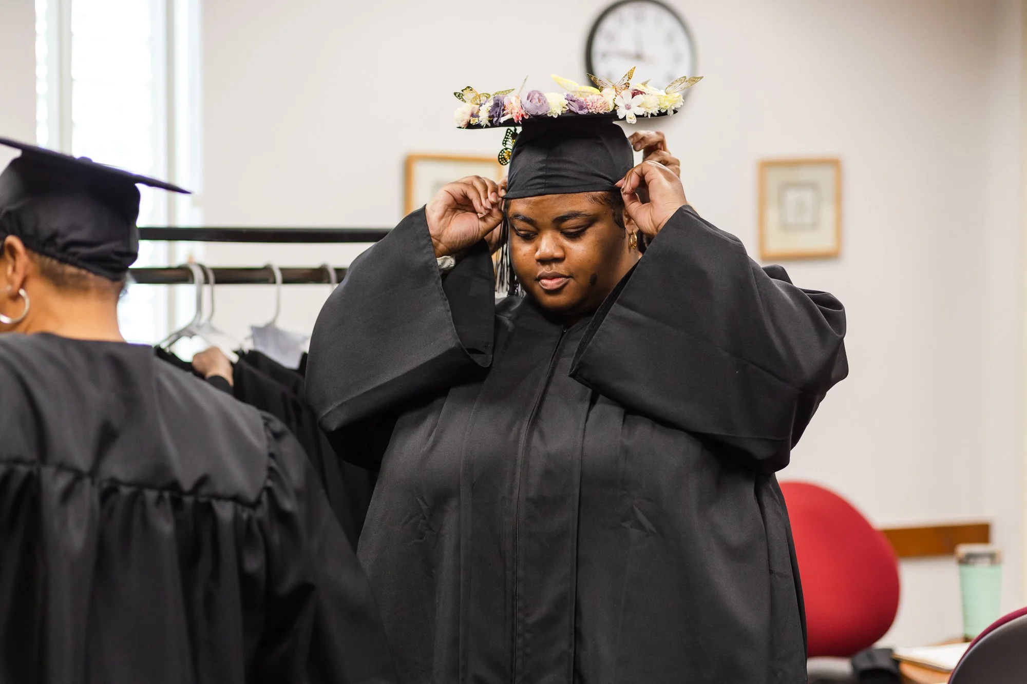 A woman fixing her cap: nonprofit graduation ceremony Detroit event photography.